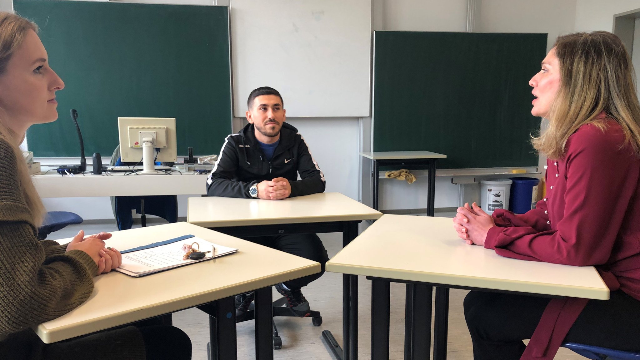 Lehrerin Marie Schwinghammer im Gespräch mit Schüler Sherwan Amou. Nadine Jaber (r.) übersetzt als Sprachmittlerin.