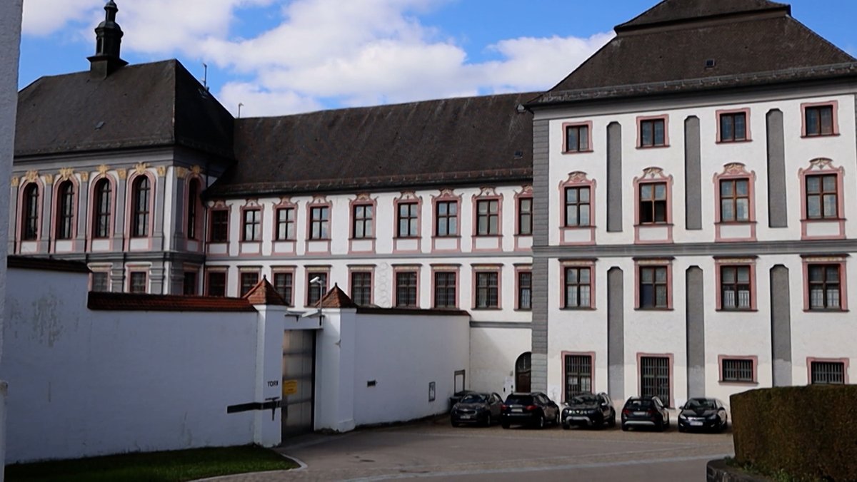 JVA Kaisheim. Der Blick auf die Gefängnismauer und das Hauptgebäude