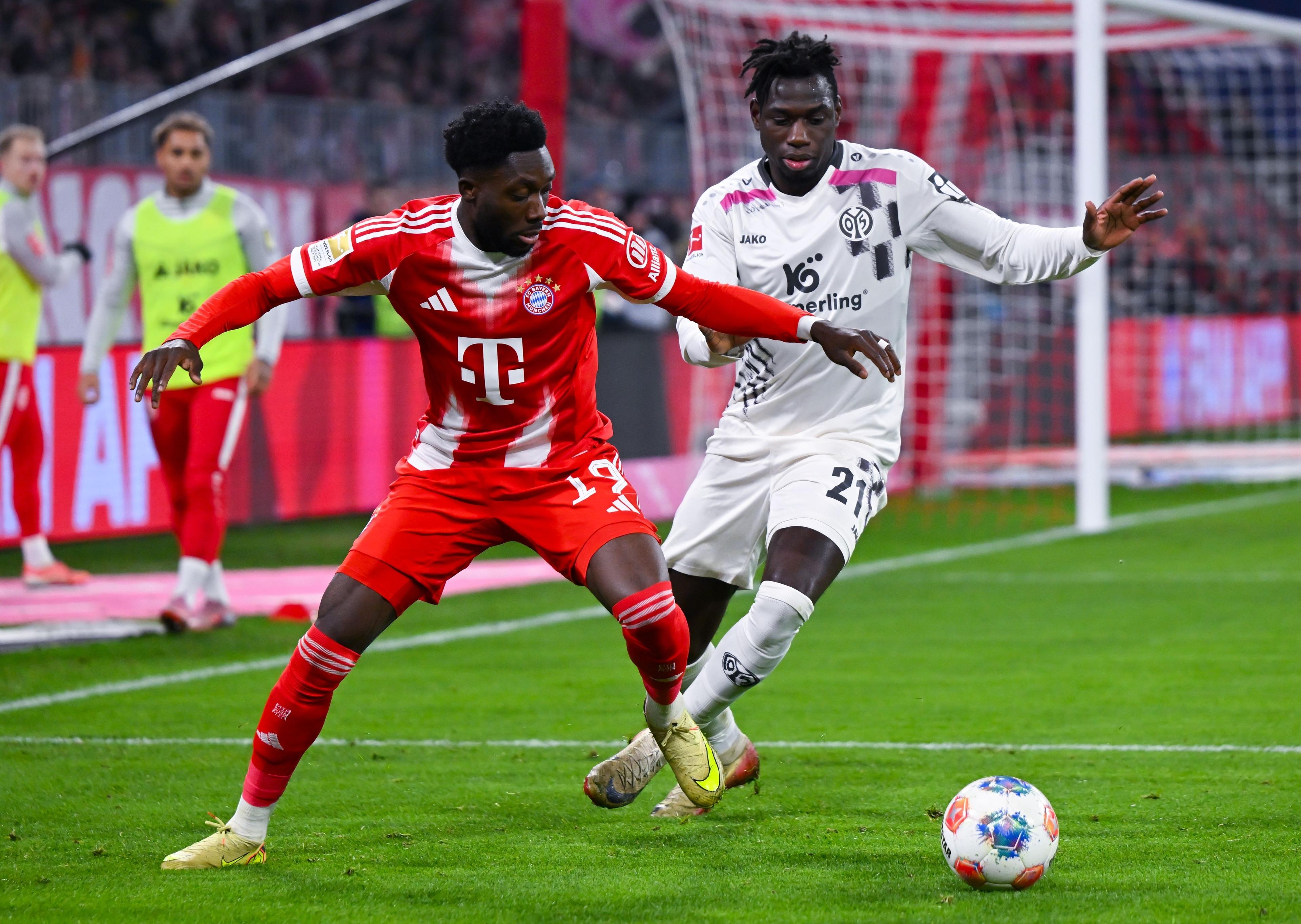 14.12.2025, Bayern, München: Fußball: Bundesliga, Bayern München - FSV Mainz 05, 14. Spieltag in der Allianz Arena. Alphonso Davies (l, Bayern München) und Danny da Costa (FSV Mainz 05) kämpfen um den Ball. Foto: Sven Hoppe/dpa - WICHTIGER HINWEIS: Gemäß den Vorgaben der DFL Deutsche Fußball Liga bzw. des DFB Deutscher Fußball-Bund ist es untersagt, in dem Stadion und/oder vom Spiel angefertigte Fotoaufnahmen in Form von Sequenzbildern und/oder videoähnlichen Fotostrecken zu verwerten bzw. verwerten zu lassen. +++ dpa-Bildfunk +++