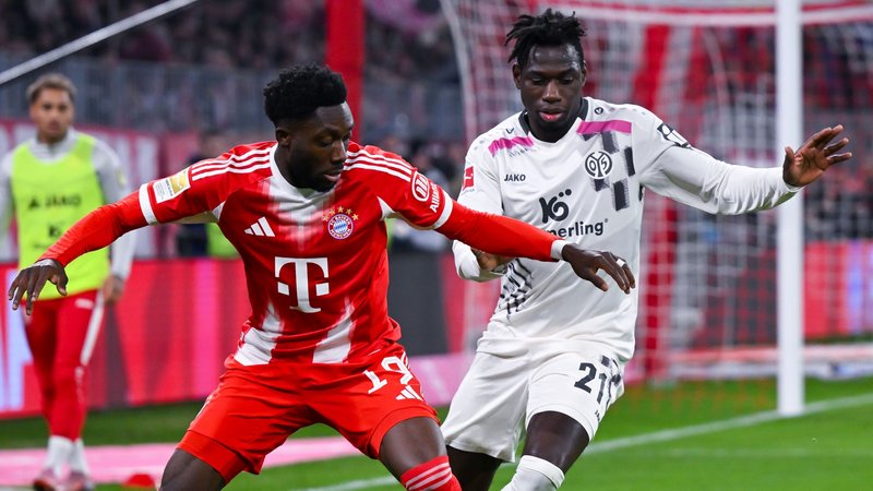 14.12.2025, Bayern, München: Fußball: Bundesliga, Bayern München - FSV Mainz 05, 14. Spieltag in der Allianz Arena. Alphonso Davies (l, Bayern München) und Danny da Costa (FSV Mainz 05) kämpfen um den Ball. Foto: Sven Hoppe/dpa - WICHTIGER HINWEIS: Gemäß den Vorgaben der DFL Deutsche Fußball Liga bzw. des DFB Deutscher Fußball-Bund ist es untersagt, in dem Stadion und/oder vom Spiel angefertigte Fotoaufnahmen in Form von Sequenzbildern und/oder videoähnlichen Fotostrecken zu verwerten bzw. verwerten zu lassen. +++ dpa-Bildfunk +++ | Bild: dpa-Bildfunk/Sven Hoppe 14.12.2025, Bayern, München: Fußball: Bundesliga, Bayern München - FSV Mainz 05, 14. Spieltag in der Allianz Arena. Alphonso Davies (l, Bayern München) und Danny da Costa (FSV Mainz 05) kämpfen um den Ball. Foto: Sven Hoppe/dpa - WICHTIGER HINWEIS: Gemäß den Vorgaben der DFL Deutsche Fußball Liga bzw. des DFB Deutscher Fußball-Bund ist es untersagt, in dem Stadion und/oder vom Spiel angefertigte Fotoaufnahmen in Form von Sequenzbildern und/oder videoähnlichen Fotostrecken zu verwerten bzw. verwerten zu lassen. +++ dpa-Bildfunk +++
