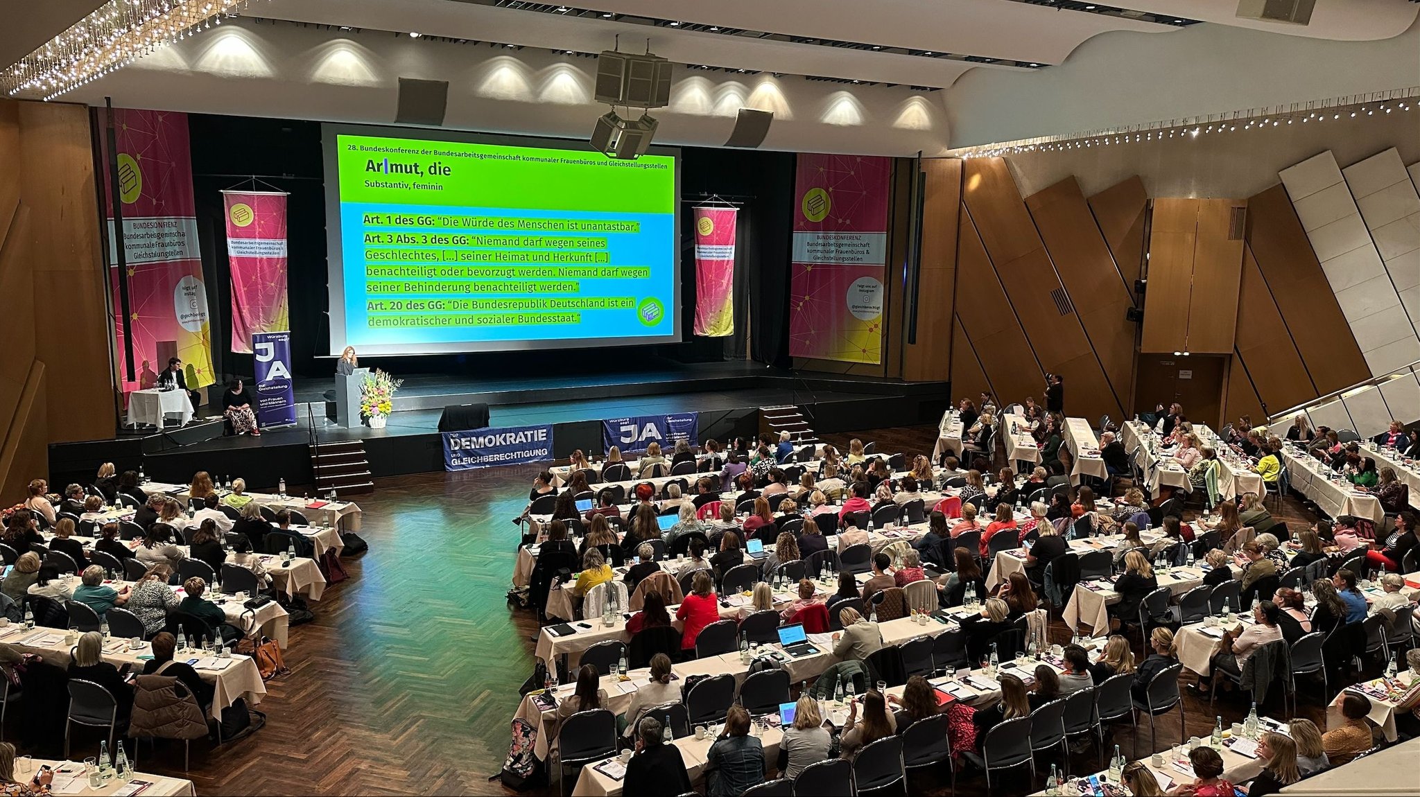 500 Menschen sitzen in großem Saal und verfolgen eine Rede bei der Bundeskonferenz der kommunalen Frauen- und Gleichstellungsbeauftragten in Würzburg