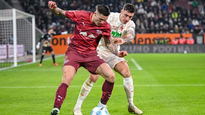 14.02.2025, Bayern, Augsburg: Fußball, Bundesliga, FC Augsburg - RB Leipzig, 22. Spieltag, WWK-Arena. Leipzigs Benjamin Sesko (l) in Aktion mit Augsburgs Cedric Zesiger. Foto: Harry Langer/dpa - WICHTIGER HINWEIS: Gemäß den Vorgaben der DFL Deutsche Fußball Liga bzw. des DFB Deutscher Fußball-Bund ist es untersagt, in dem Stadion und/oder vom Spiel angefertigte Fotoaufnahmen in Form von Sequenzbildern und/oder videoähnlichen Fotostrecken zu verwerten bzw. verwerten zu lassen. +++ dpa-Bildfunk +++ | Bild: dpa-Bildfunk/Harry Langer 14.02.2025, Bayern, Augsburg: Fußball, Bundesliga, FC Augsburg - RB Leipzig, 22. Spieltag, WWK-Arena. Leipzigs Benjamin Sesko (l) in Aktion mit Augsburgs Cedric Zesiger. Foto: Harry Langer/dpa - WICHTIGER HINWEIS: Gemäß den Vorgaben der DFL Deutsche Fußball Liga bzw. des DFB Deutscher Fußball-Bund ist es untersagt, in dem Stadion und/oder vom Spiel angefertigte Fotoaufnahmen in Form von Sequenzbildern und/oder videoähnlichen Fotostrecken zu verwerten bzw. verwerten zu lassen. +++ dpa-Bildfunk +++