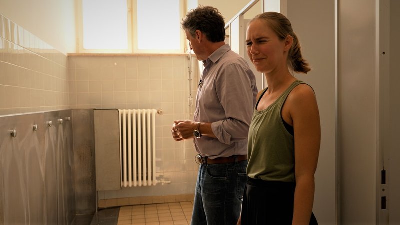 Schulleiter Michael Böck steht zusammen mit Elternbeirätin Anja Waninger in der Schul-Toilette. Es stinkt nach Urin, Waninger schaut angeekelt in die Kamera. | Bild: BR/Andreas Herz Schulleiter Michael Böck steht zusammen mit Elternbeirätin Anja Waninger in der Schul-Toilette. Es stinkt nach Urin, Waninger schaut angeekelt in die Kamera.