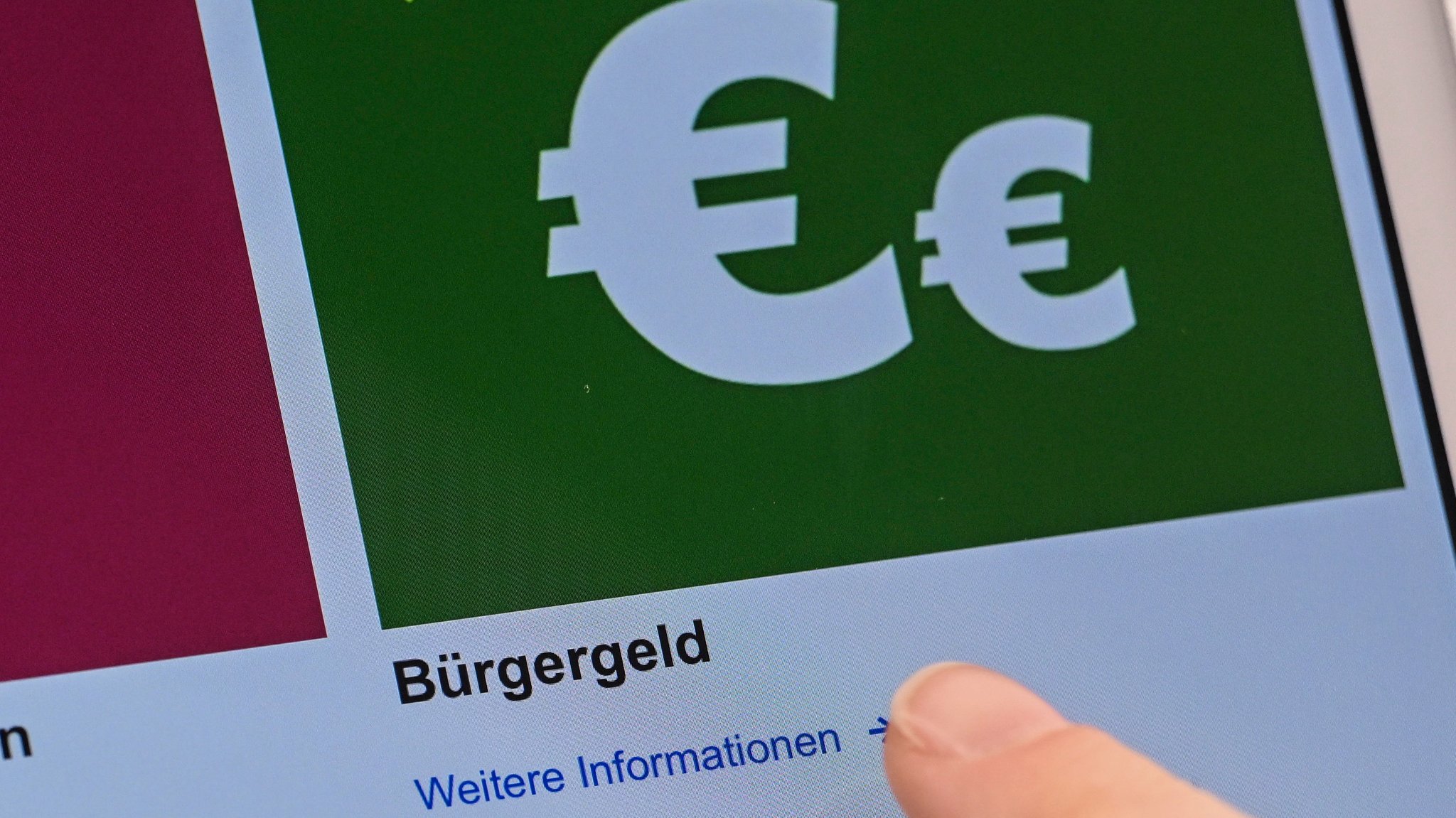Auf einem Display in einem Berliner Jobcenter werden Onlineangebote rund um das Bürgergeld abgerufen.