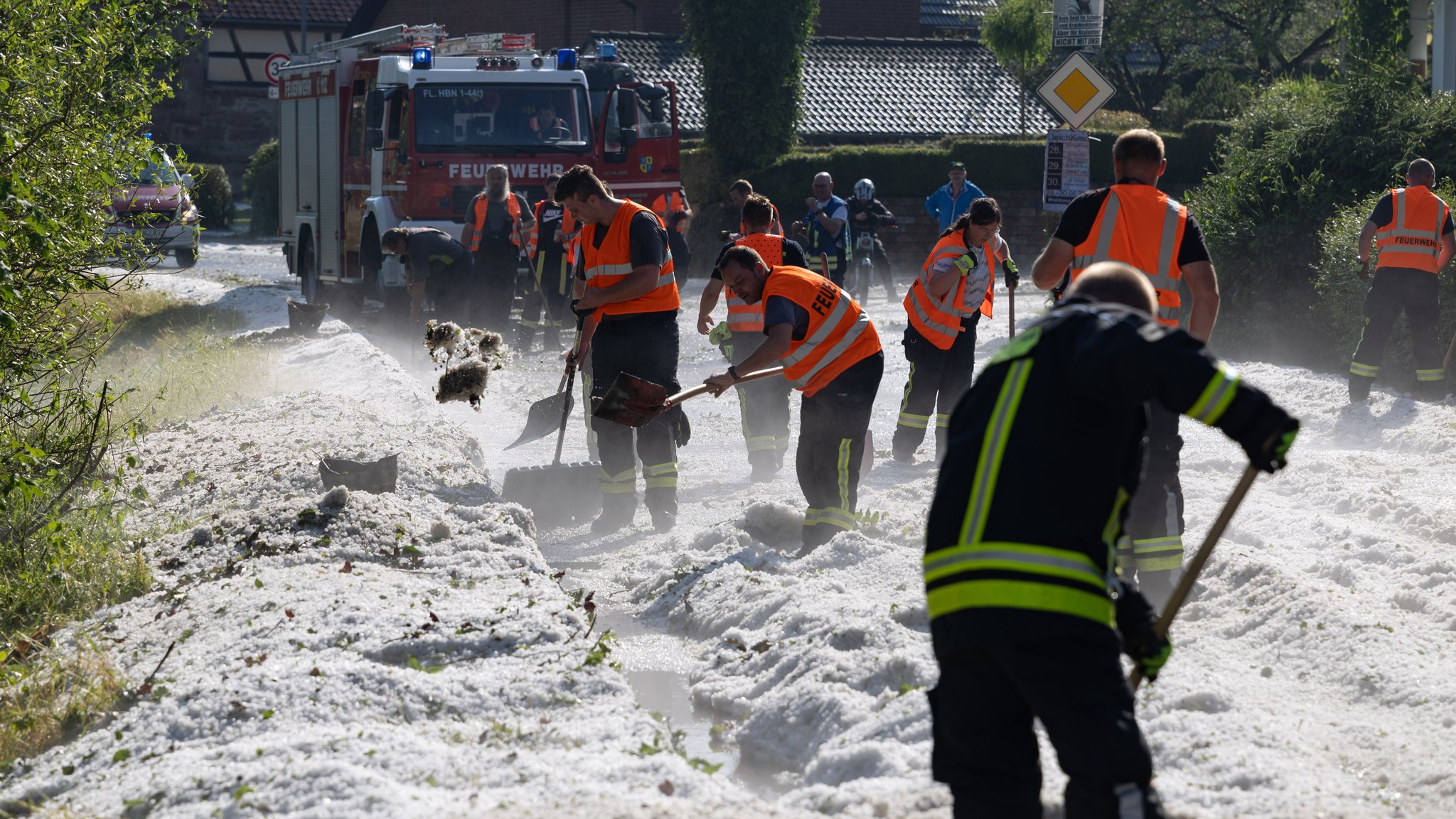 Einsatzkräfte der Polizei räumen eine Straße im Hildburghauser Ortsteil Weitersroda von Hagel. 