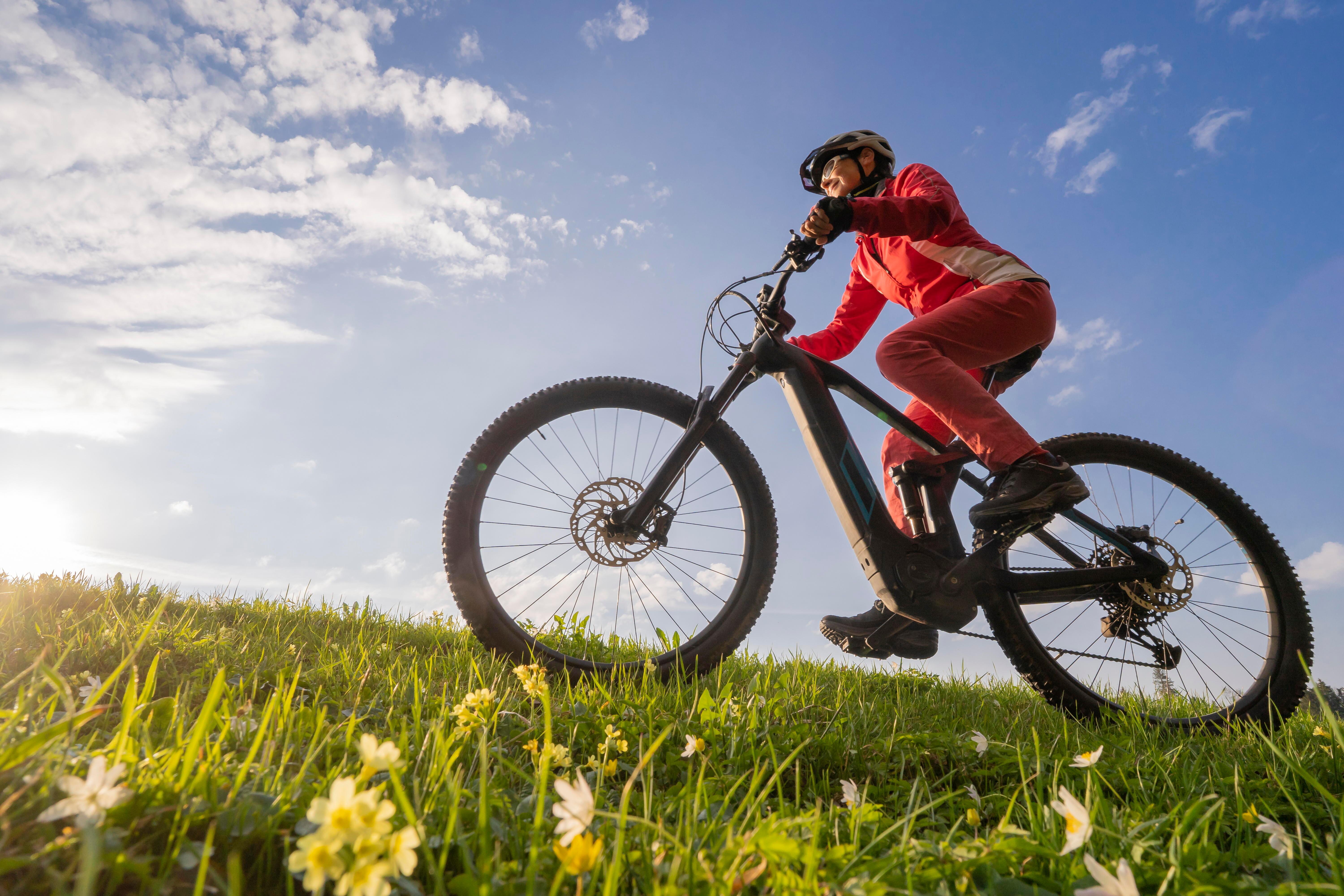 Eine ältere Frau auf einem E-Bike in der Natur