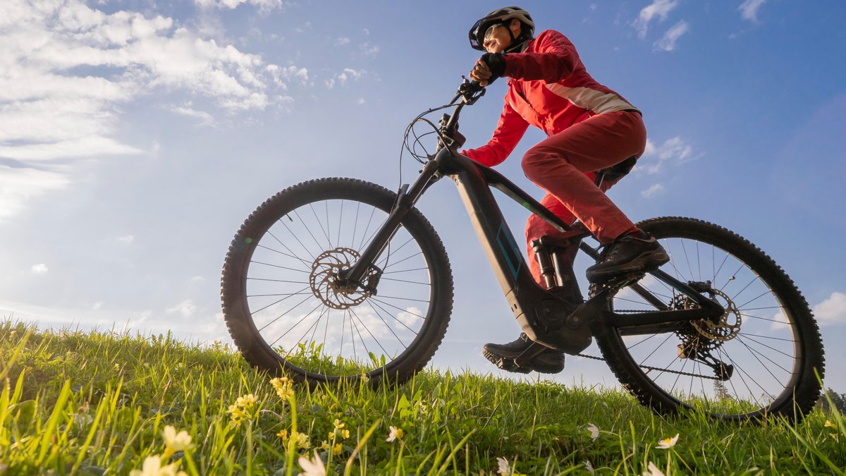 Eine ältere Frau auf einem E-Bike in der Natur