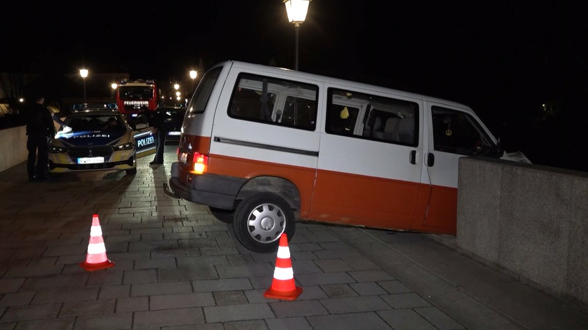 Ein VW Bus auf der Steinernen Brücke in Regensburg ragt mit der Front über den Abgrund