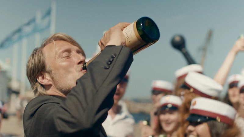 Ein Mann mit einer Flasche Alkohol im Sonnenschein.
