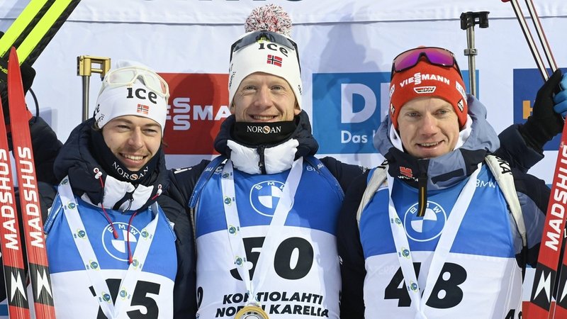 Sturla Holm Laegreid, Silbermedaillengewinner aus Norwegen, Johannes Thingnes Boe, Goldmedaillengewinner aus Norwegen, und Roman Rees, Bronzemedaillengewinner aus Deutschland jubeln auf dem Podium. 