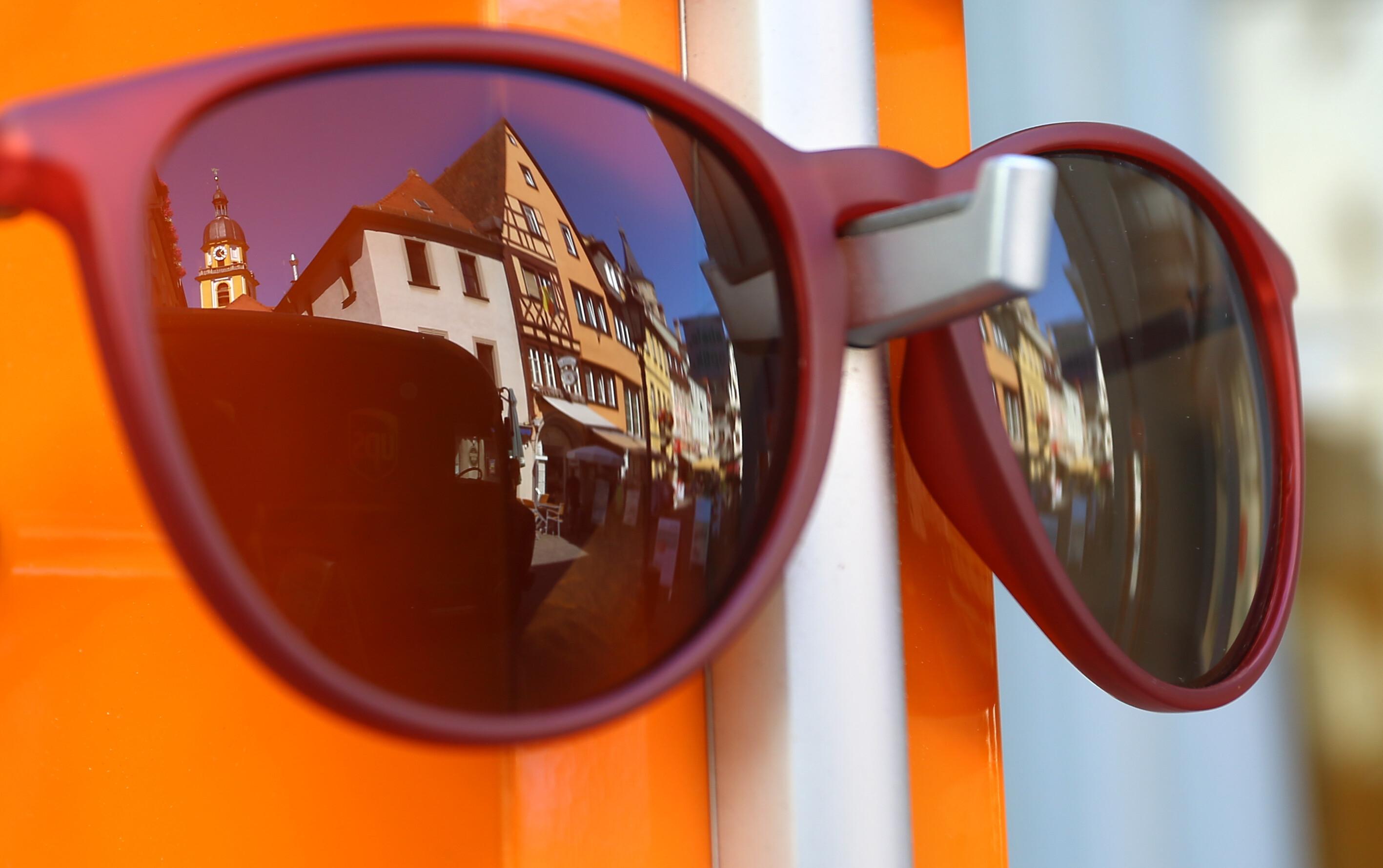 Die Altstadt von Kitzingen spiegelt sich in einer Sonnenbrille in der Auslage eines Geschäftes.