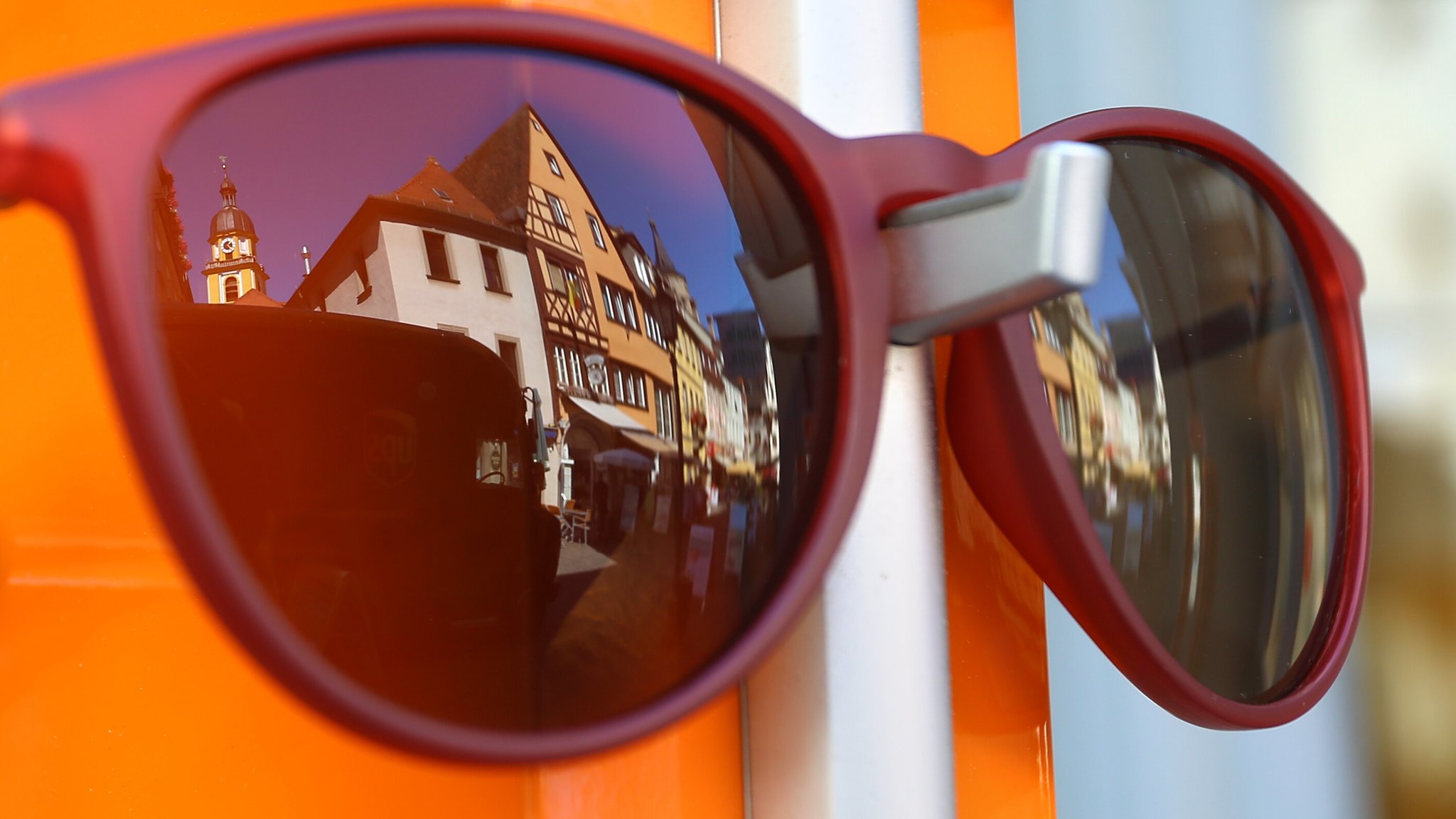 Die Altstadt von Kitzingen spiegelt sich in einer Sonnenbrille in der Auslage eines Geschäftes.