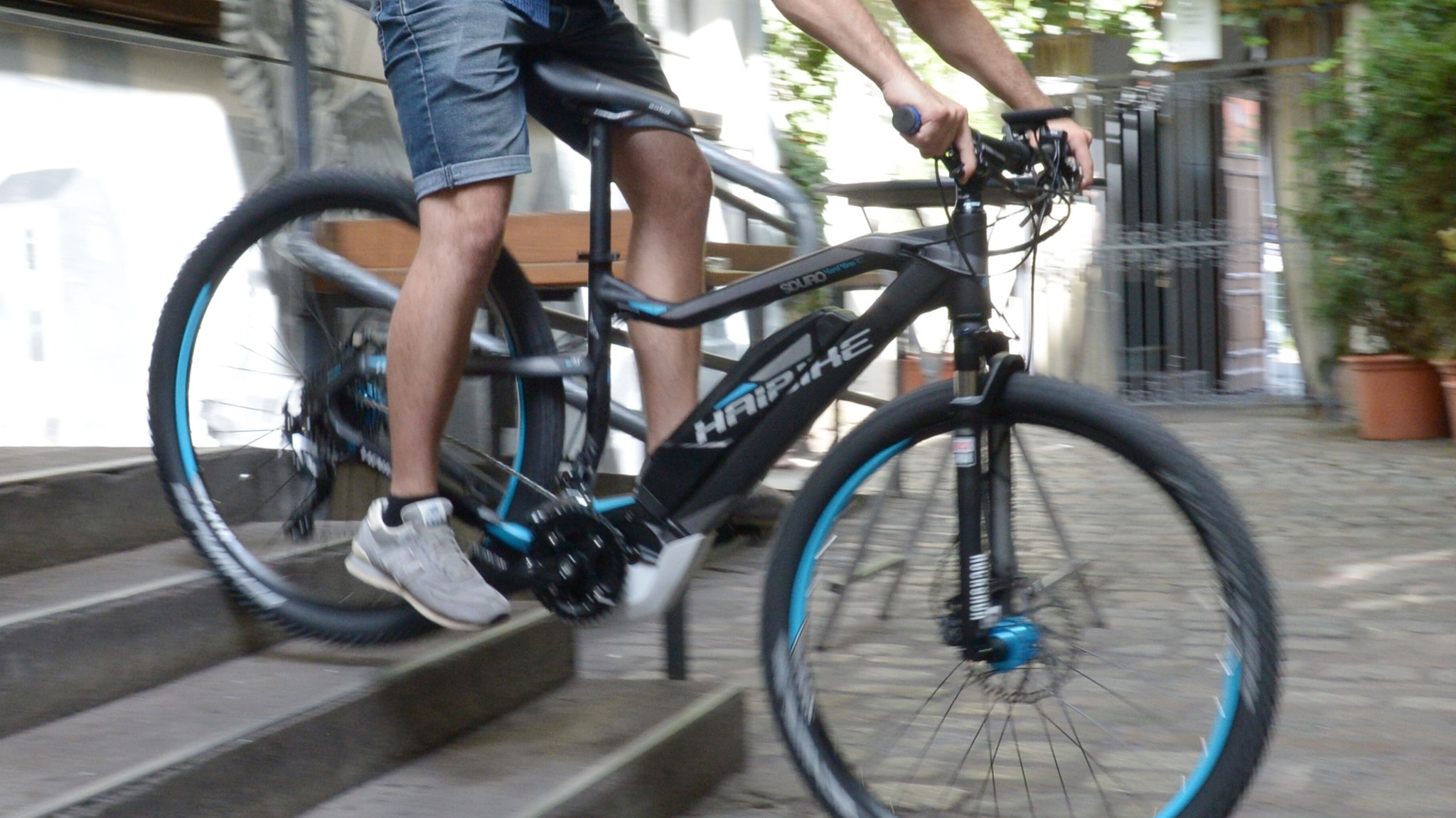 Ein Mann fährt mit einem Mountainbike der Marke Haibike eine Treppe hinunter. 