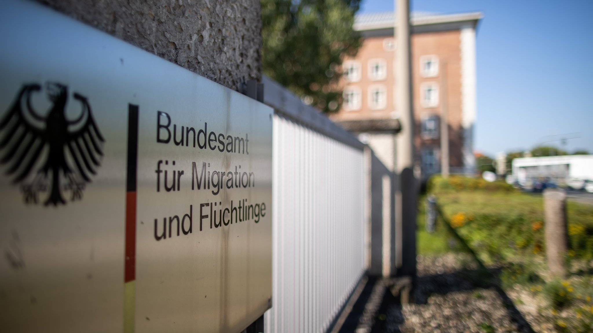 "Bundesamt für Migration und Flüchtlinge" steht auf einem Schild vor dem Gebäude. | Bild: Daniel Karmann/dpa "Bundesamt für Migration und Flüchtlinge" steht auf einem Schild vor dem Gebäude.