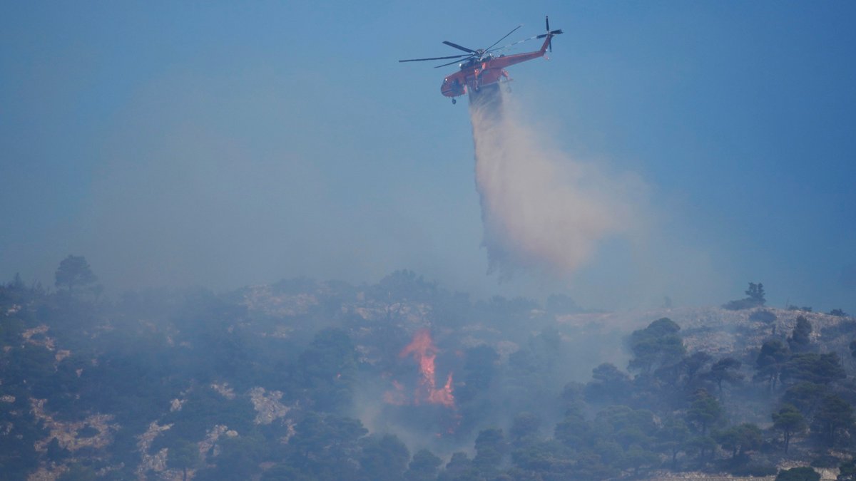 Ein Hubschrauber wirft Wasser über einem Waldbrand in Griechenland ab