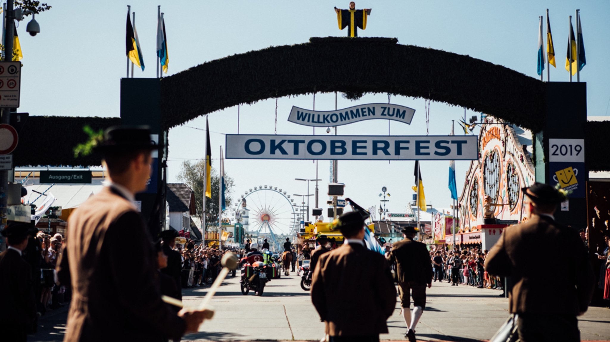 Impressionen vom Einzug der Wiesnwirte beim 186. Oktoberfest in München. Besucher auf der Fußgängerbrücke zur Festwiese. Eingang zur Wirtsbudenstraße.