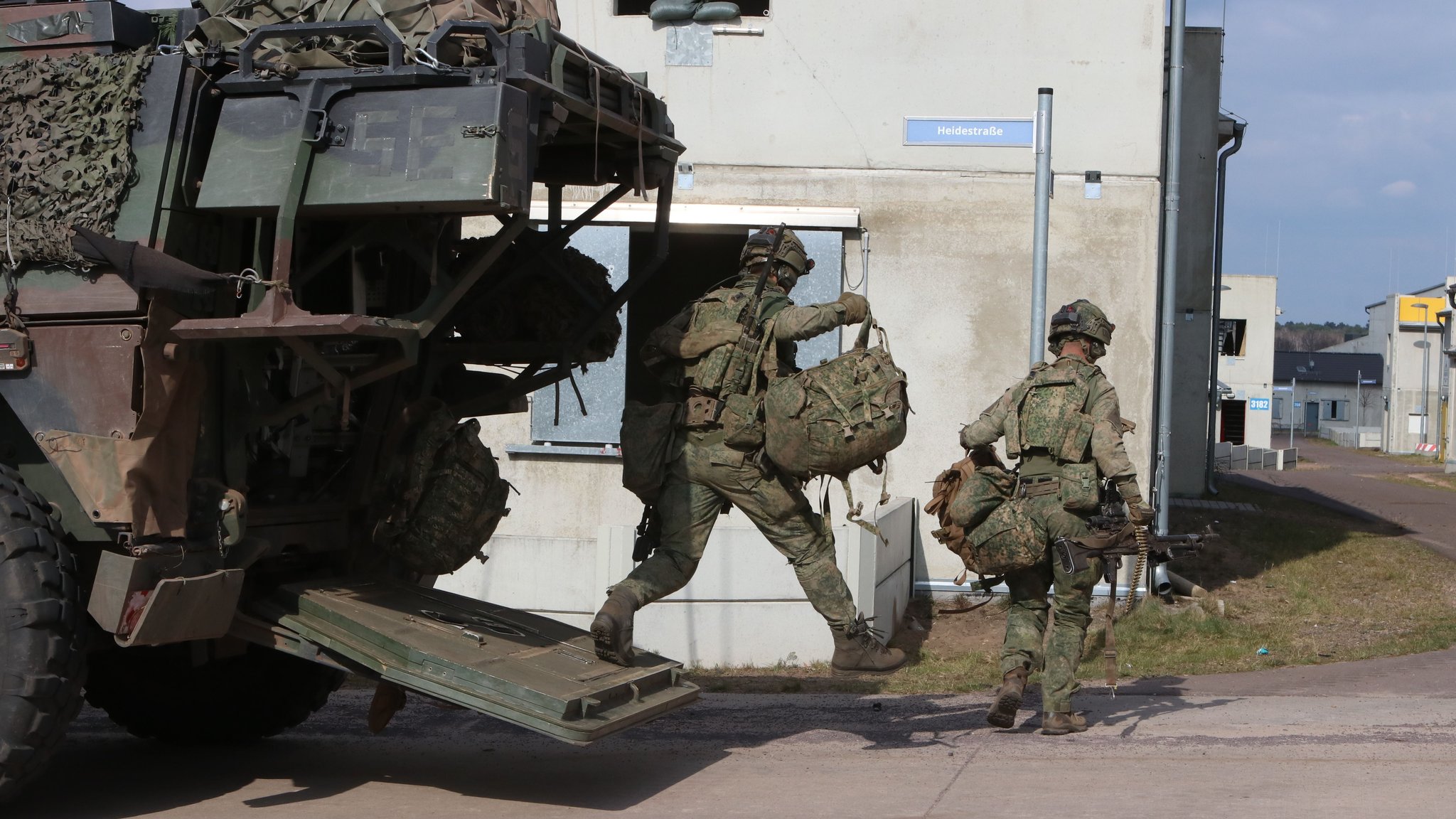 Niederländische Soldaten springen aus einem Radpanzer. Sie erobern "Schnöggersburg" im Rahmen eines derzeit laufenden Großmanövers von "roten" Feindkräften zurück. | Bild: Kilian Neuwert, BR Niederländische Soldaten springen aus einem Radpanzer. Sie erobern "Schnöggersburg" im Rahmen eines derzeit laufenden Großmanövers von "roten" Feindkräften zurück.