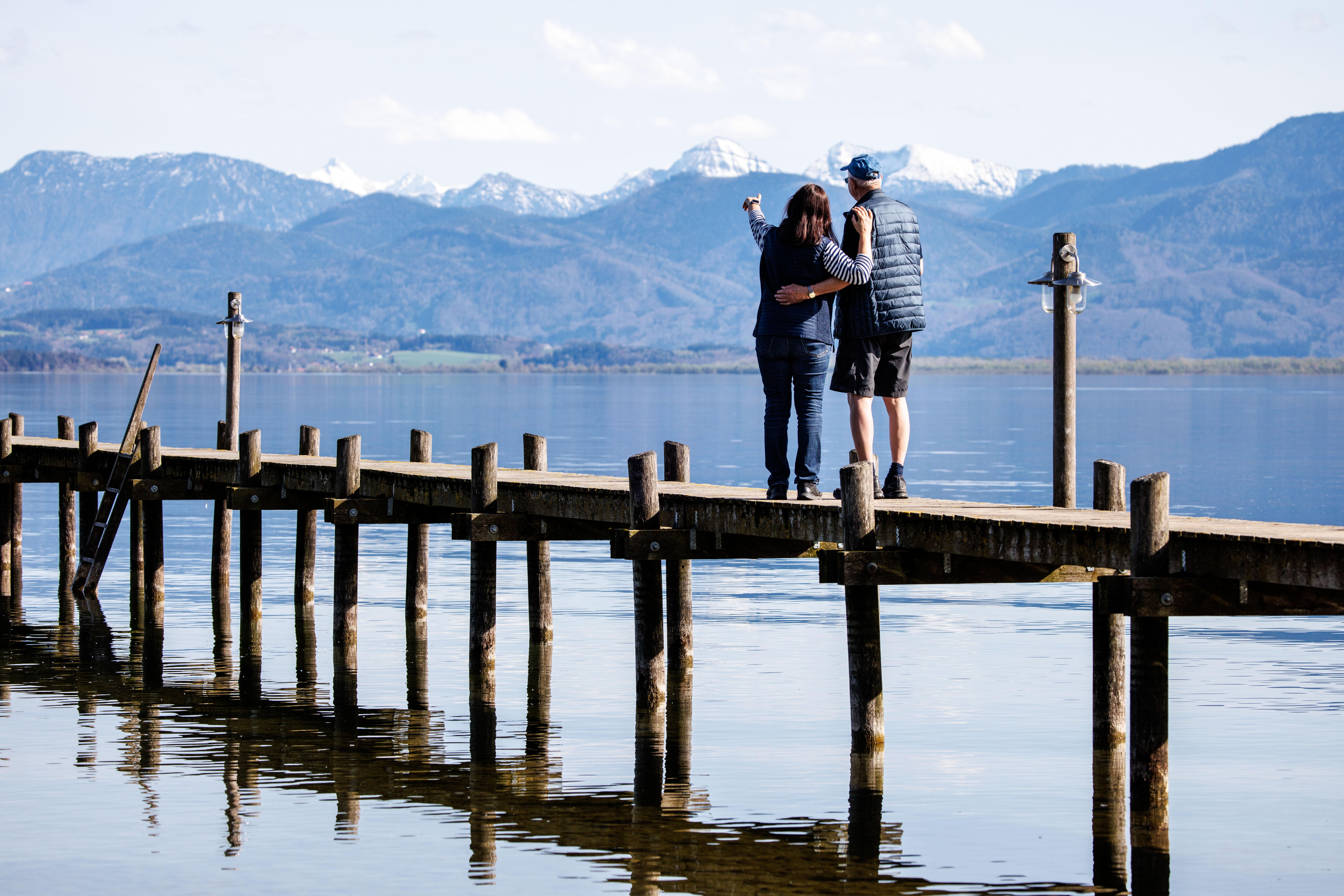 Ein Mann und eine Frau stehen gemeinsam auf einem Steg am Chiemsee