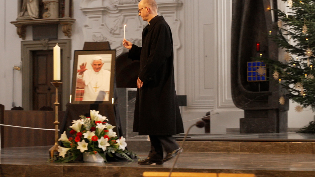 Der Würzburger Bischof Franz Jung entzündet eine Kerze im Dom, zum Gedenken an den verstorbenen Papst Benedikt.