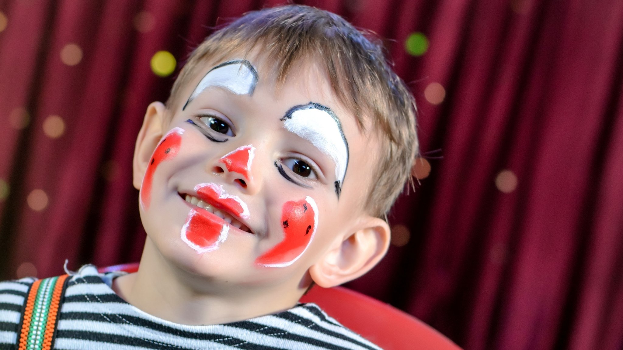 Als Clown geschminkter Junge