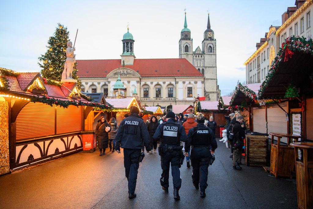 22.12.2024, Sachsen-Anhalt, Magdeburg: Polizisten und Passanten gehen über den geschlossenen Magdeburger Weihnachtsmarkt. Am 20. Dezember 2024 ist auf dem Weihnachtsmarkt in Magdeburg ein Autofahrer in eine Menschengruppe gefahren. Es gab mehrere Tote und Verletzte. Die Sperrung des Tatortes war am Nachmittag aufgehoben worden. Foto: Klaus-Dietmar Gabbert/dpa +++ dpa-Bildfunk +++