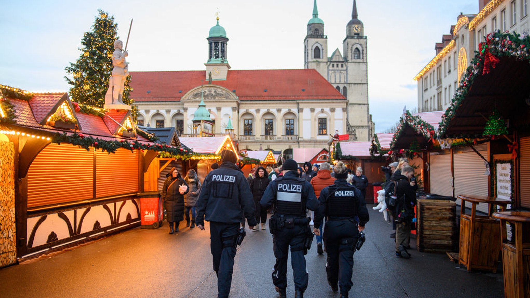 22.12.2024, Sachsen-Anhalt, Magdeburg: Polizisten und Passanten gehen über den geschlossenen Magdeburger Weihnachtsmarkt. Am 20. Dezember 2024 ist auf dem Weihnachtsmarkt in Magdeburg ein Autofahrer in eine Menschengruppe gefahren. Es gab mehrere Tote und Verletzte. Die Sperrung des Tatortes war am Nachmittag aufgehoben worden. Foto: Klaus-Dietmar Gabbert/dpa +++ dpa-Bildfunk +++