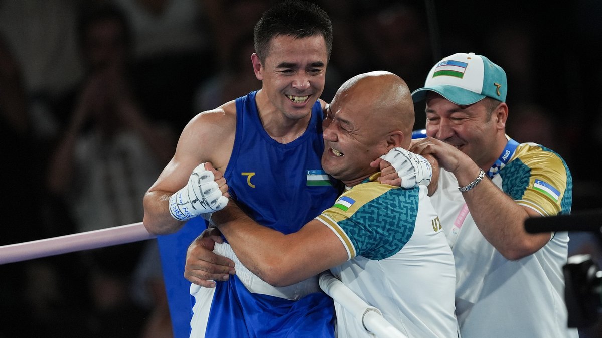 Der usbekische Boxer Hasanboy Dusmatov feiert mit seinen Trainern den Olympiasieg.