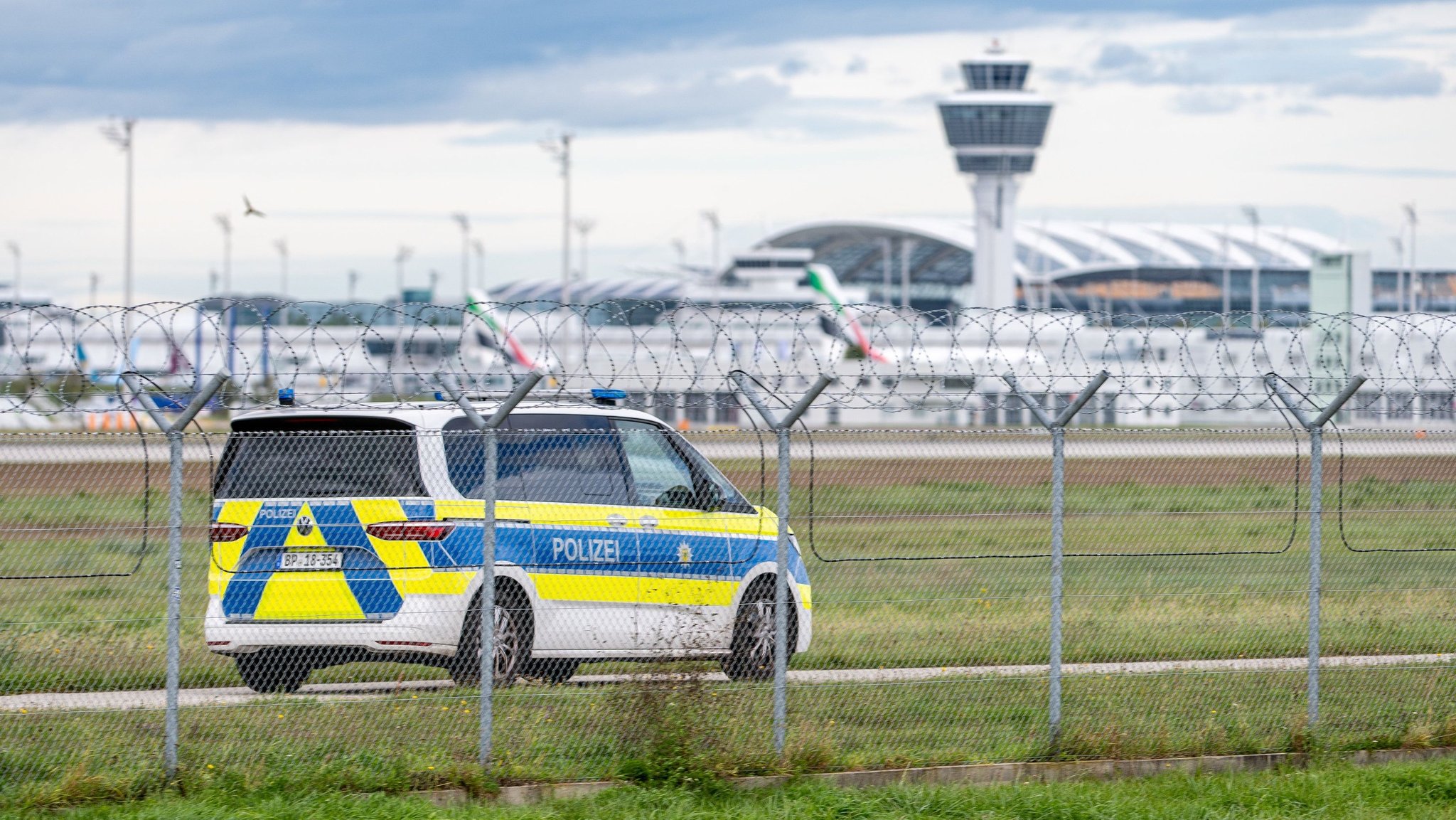 Ein Polizeifahrzeug fährt auf dem Gelände des Münchner Flughafens. | Bild: dpa-Bildfunk/Armin Weigel Ein Polizeifahrzeug fährt auf dem Gelände des Münchner Flughafens.