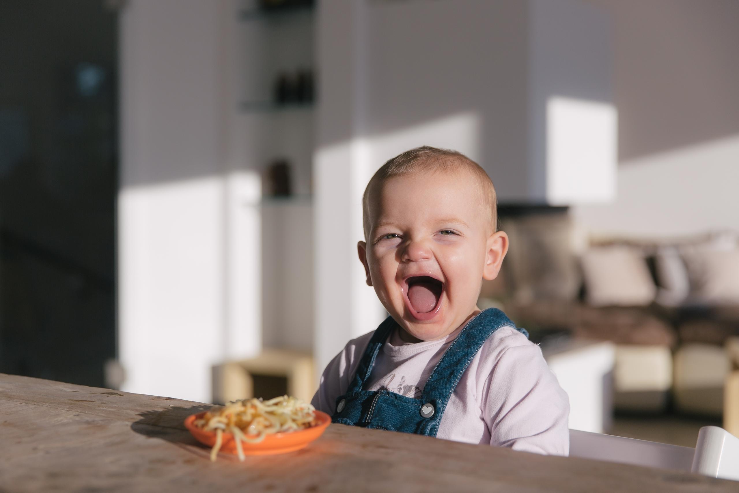 Ein kleines Mädchen lacht herzlich. 
