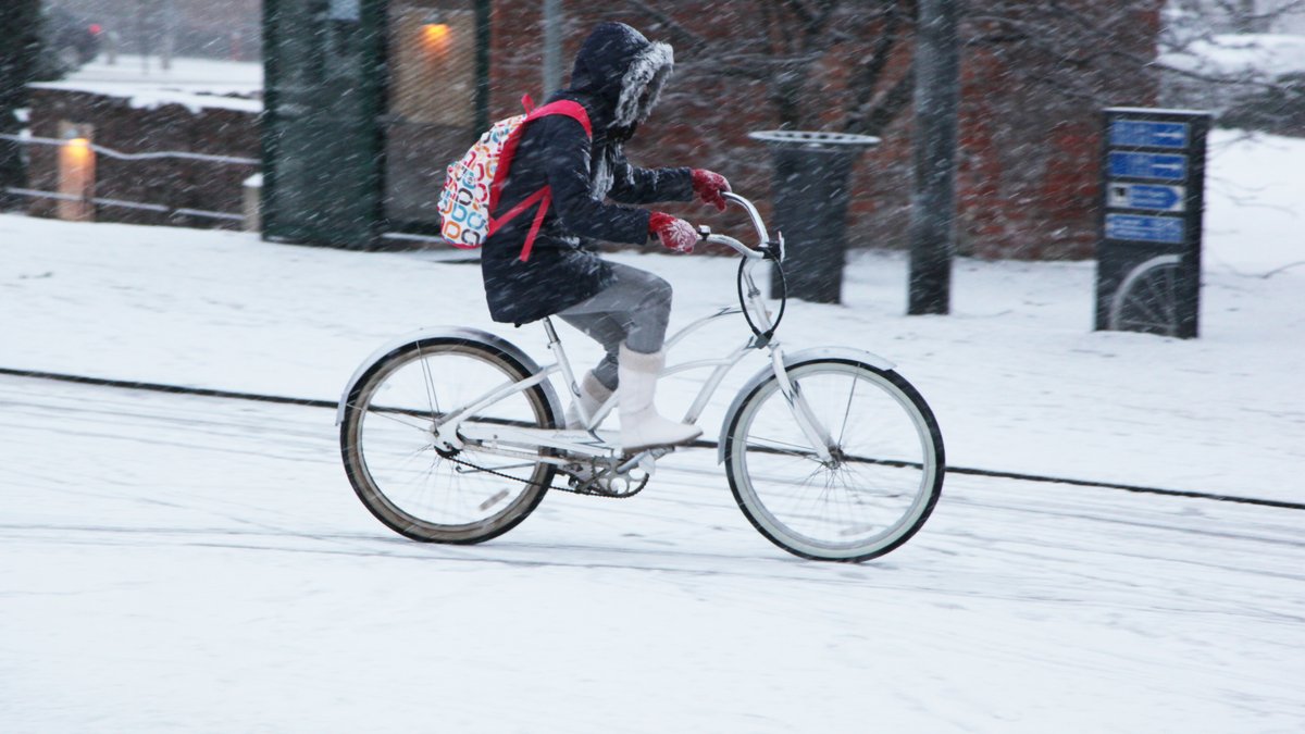 Mädchen auf einem Fahrrad auf verschneiter Straße