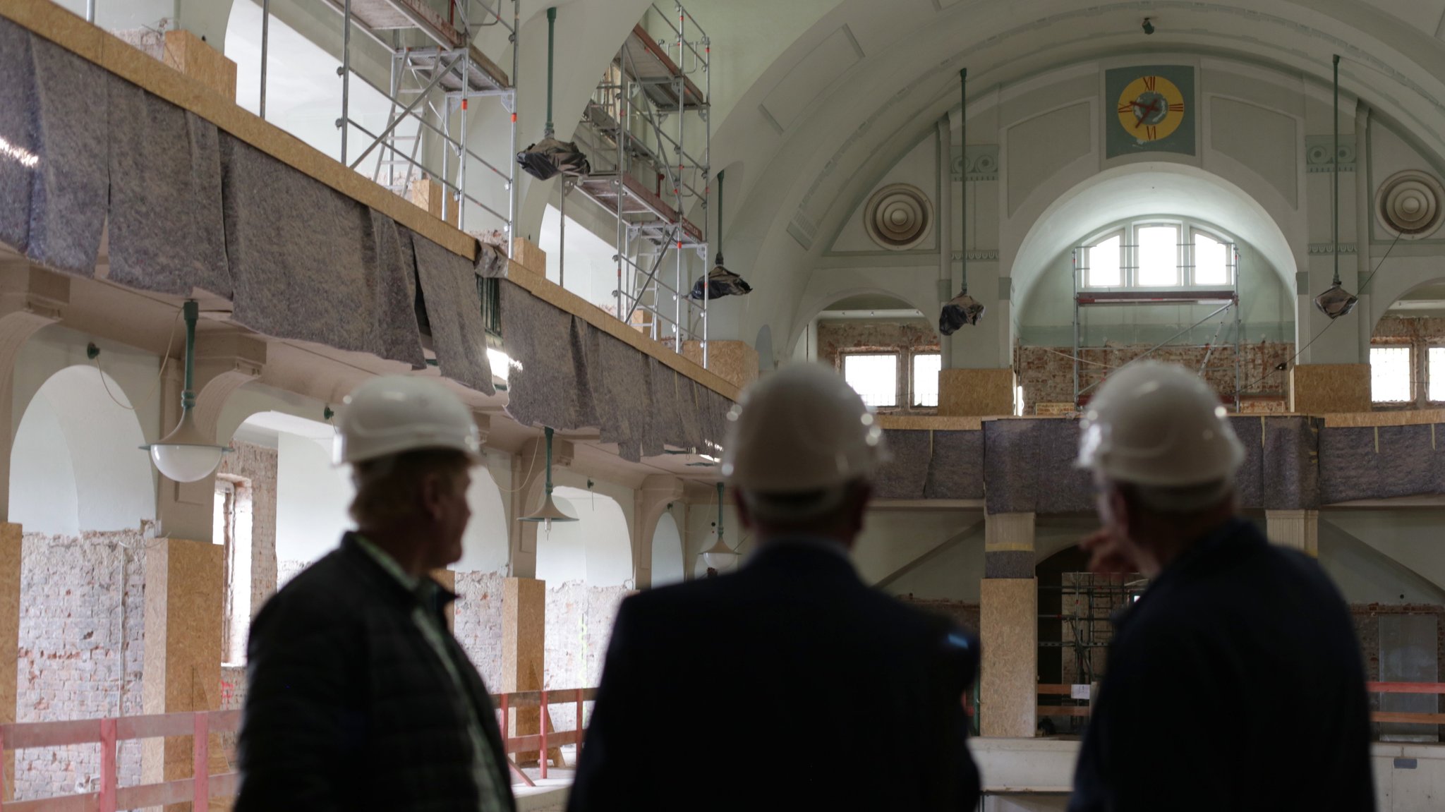 Männer mit Bauhelmen stehen in der Baustelle Volksbad in Nürnberg.