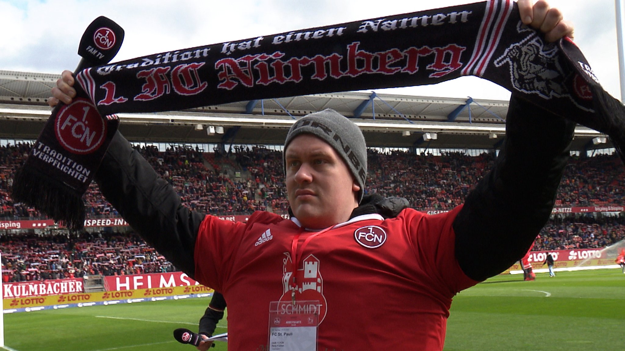 Rene Funken steht vor der Nordkurve im Max-Morlock-Stadion, hält seinen Fanschal in die Höhe und sing die Vereinshymne "Die Legende lebt". 