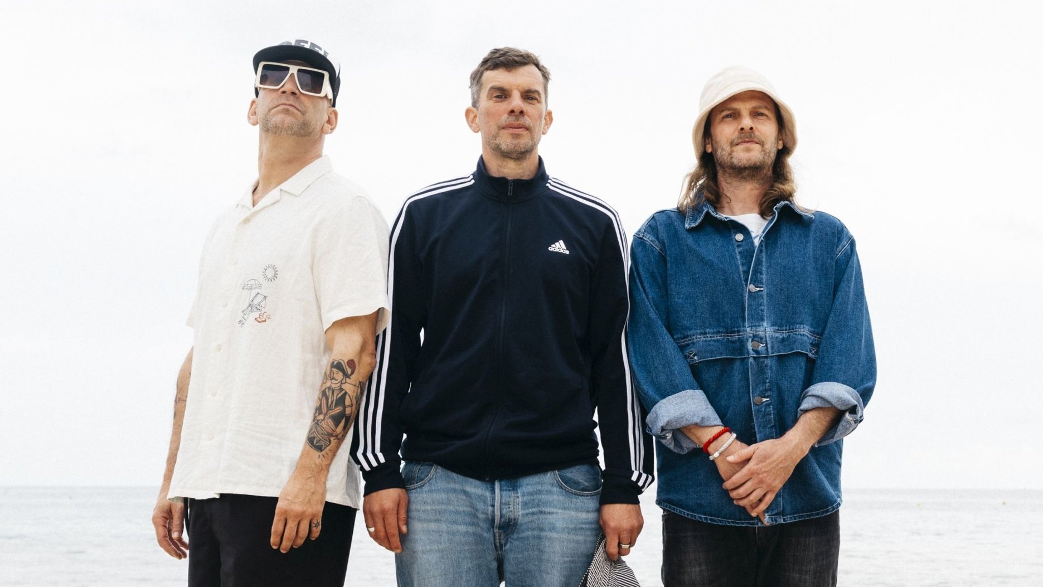Die drei Musiker der deutschen Band Sportfreunde Stiller stehen nebeneinander