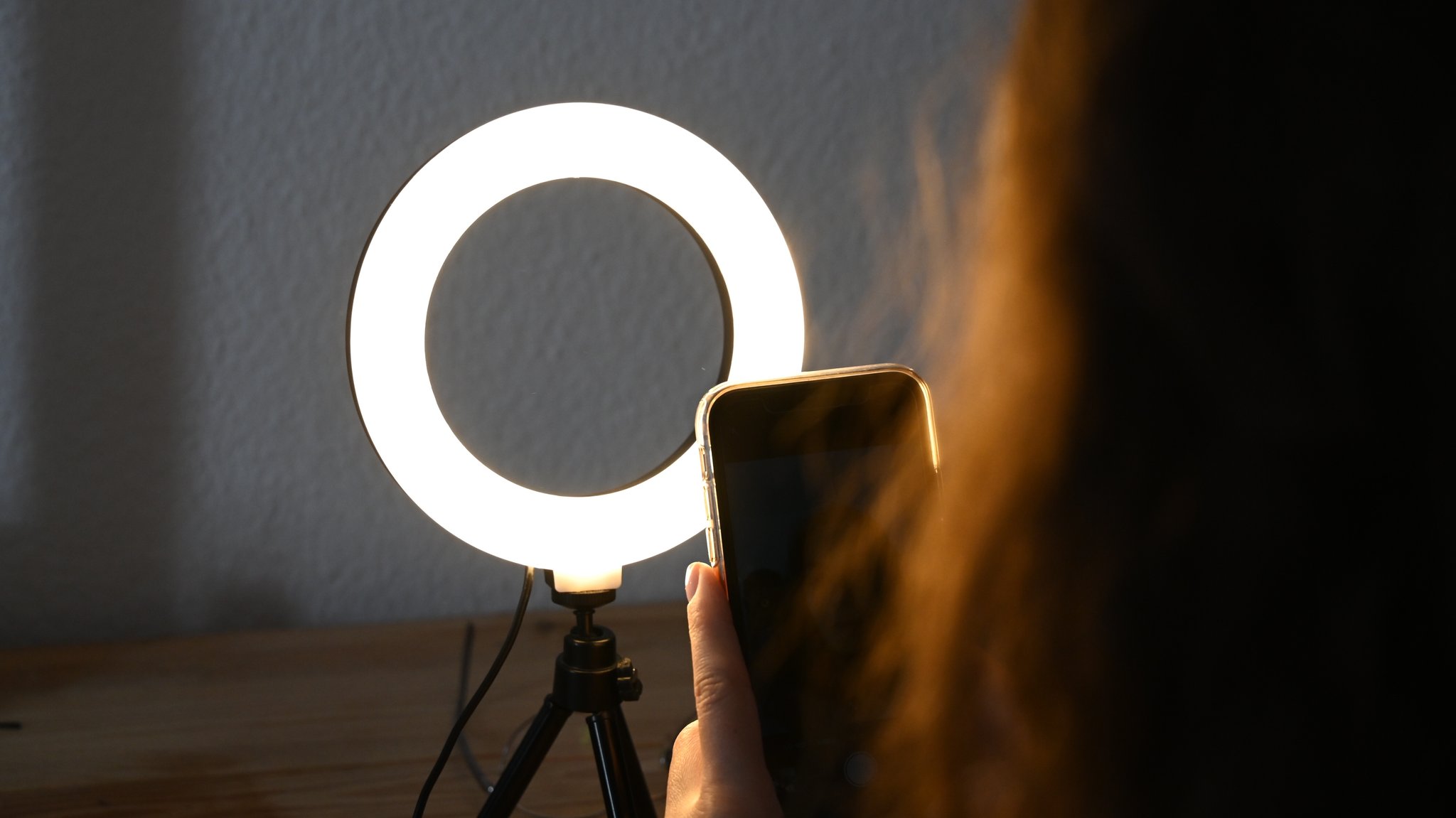 Eine Frau sitzt hinter einem Ringlicht und macht Aufnahmen von sich | Bild: picture-alliance Eine Frau sitzt hinter einem Ringlicht und macht Aufnahmen von sich