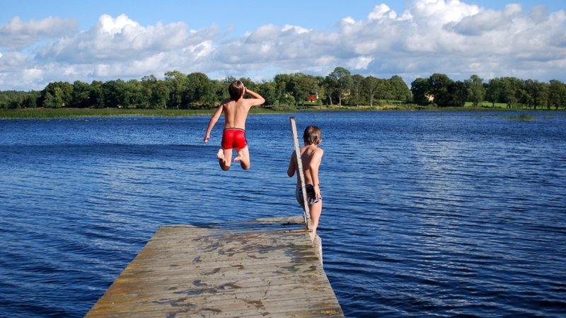 Zwei Jungen springen in Badesee (Symbolbild)