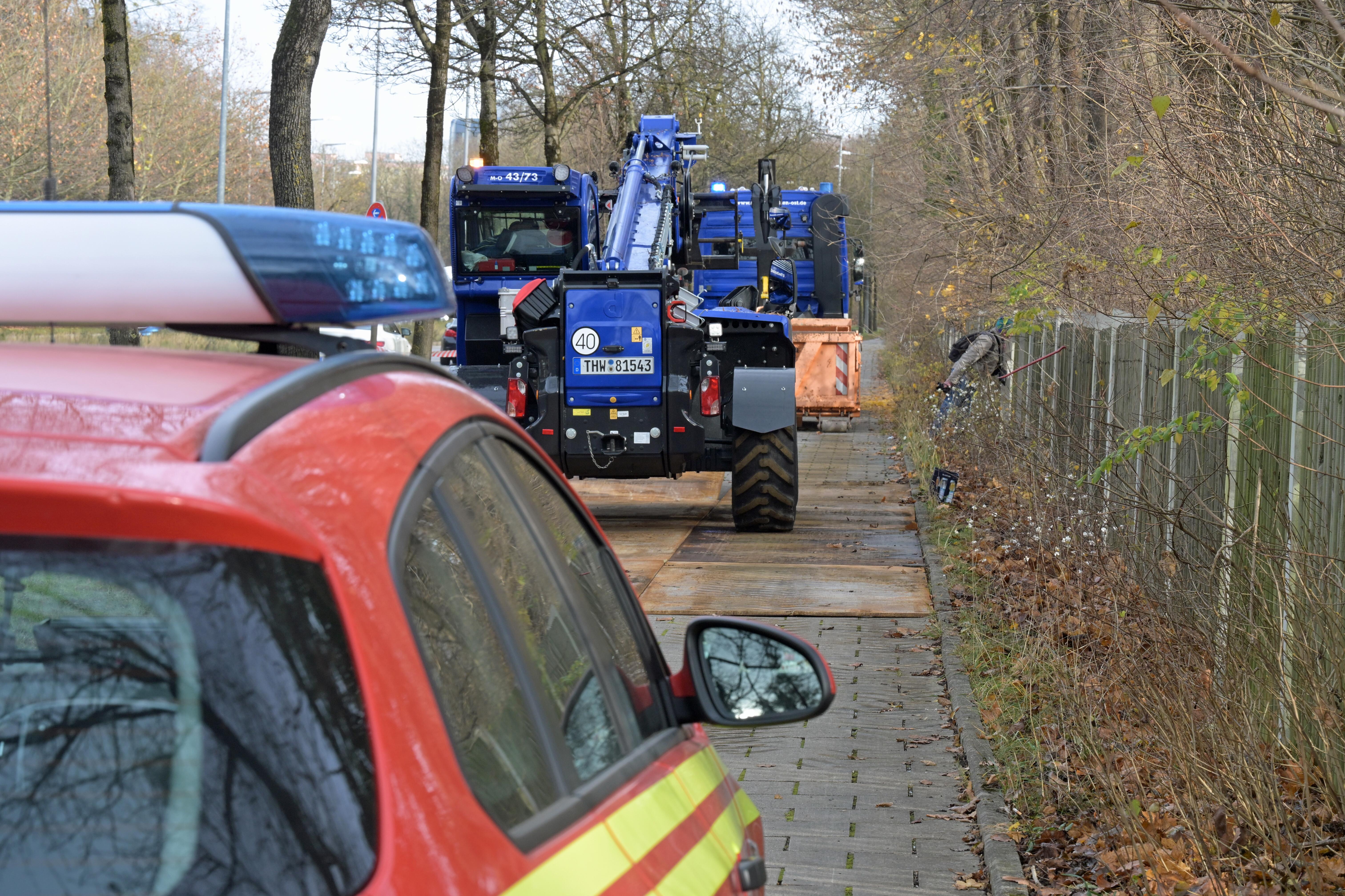 Rettungskräfte stehen an einer Einsatzstelle am Rande des Westfriedhofs im Stadtteil Moosbach, an der eine 500 Kilogramm schwere Fliegerbombe aus dem Zweiten Weltkrieg gefunden wurde.