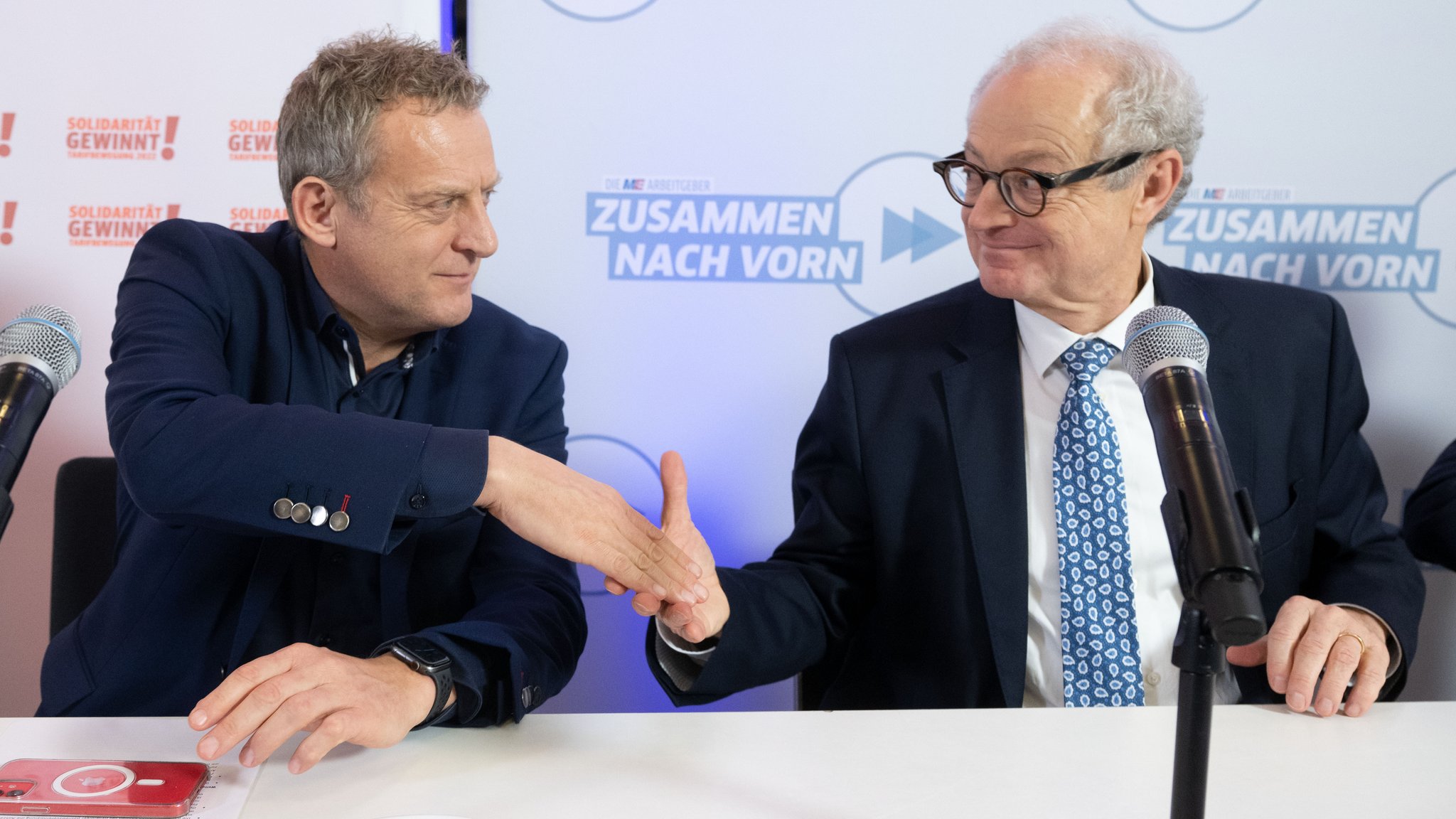 Roman Zitzelsberger (l), Bezirksleiter der IG Metall Baden-Württemberg, und Harald Marquardt, stellvertretender Vorsitzender Südwestmetall, geben sich nach einer Pressekonferenz, in der die Ergebnisse der Tarifverhandlungen der Metall- und Elektroindustrie vorgestellt wurden, die Hand. Im Tarifkonflikt der Metall- und Elektroindustrie gibt es eine Einigung.