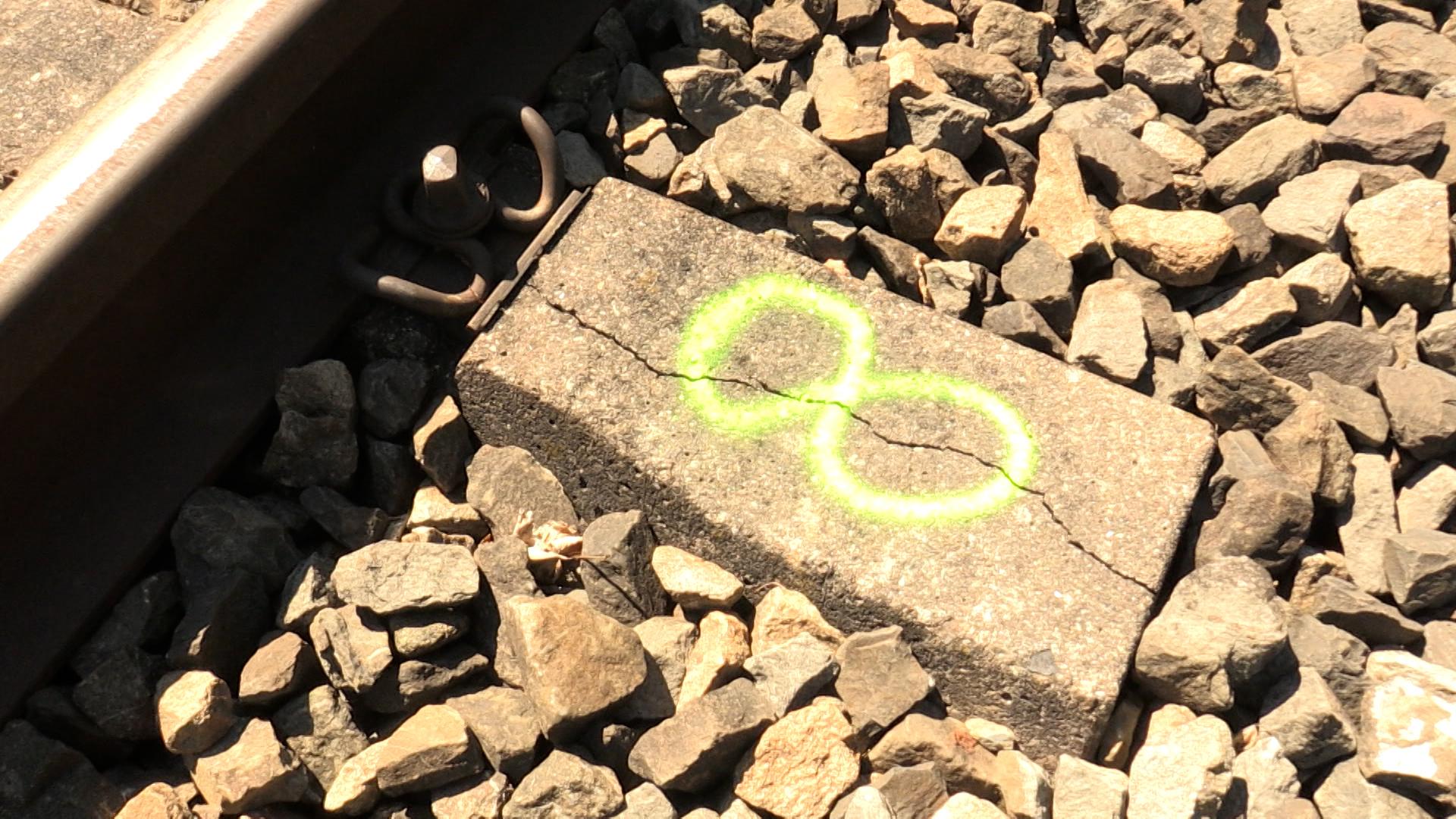 Eine gerissene Eisenbahnschwelle wurde mit Farbspray markiert