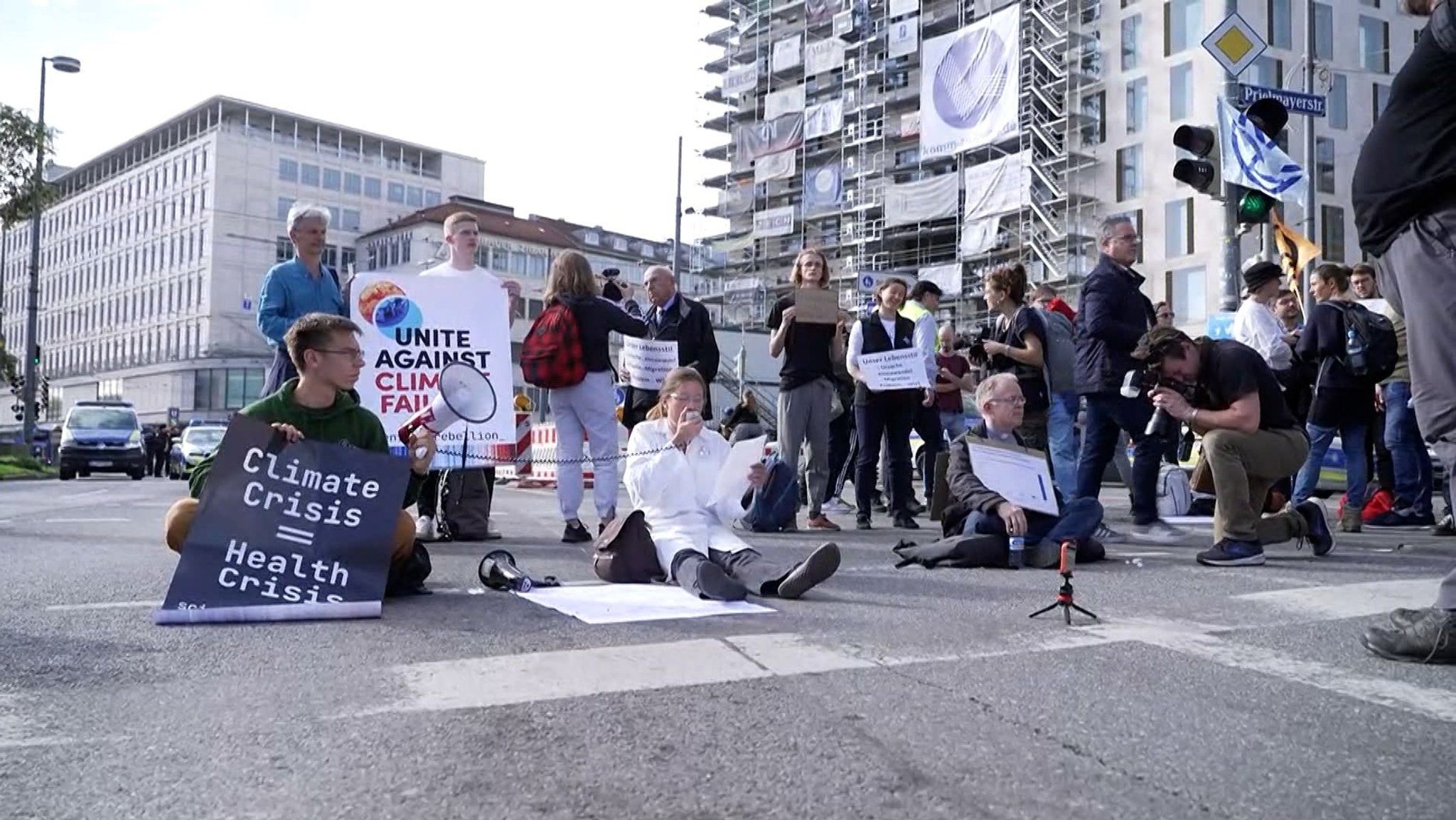 Jesuitenpater Jörg Alt (sitzend rechts) blockiert am 28. Oktober 2022 zusammen mit anderen Klimaaktivsten von Scientist Rebellion eine Fahrbahn am Stachus.