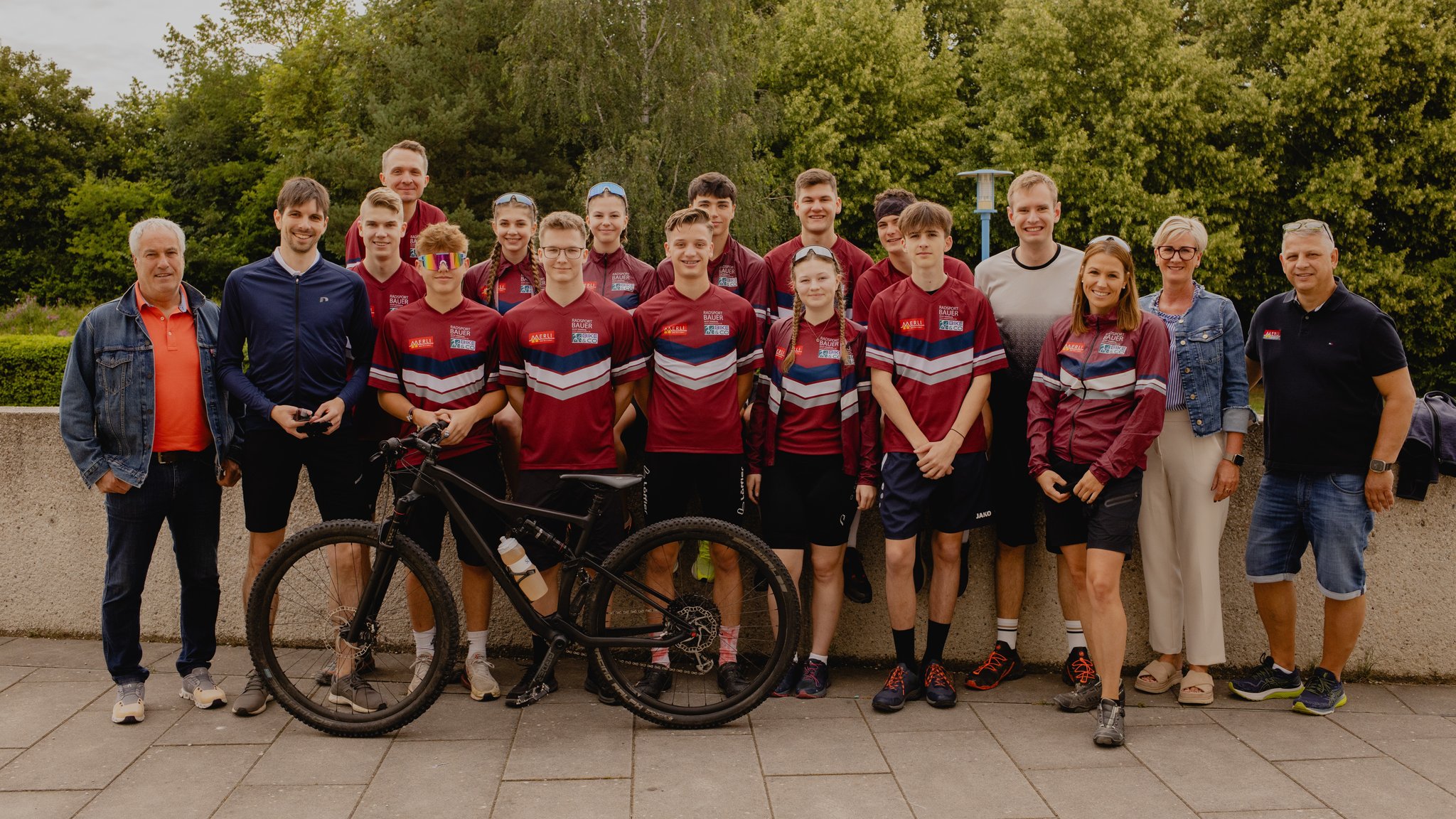 Eine Gruppe in Sportkleidung mit Fahrrad.