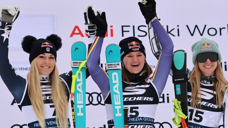 18.01.2026, Italien, Tarvisio: Ski alpin: Weltcup, Super G, Frauen: Die deutsche Emma Aicher (M), Siegerin im alpinen Ski-Weltcup-Super-G der Damen, feiert auf dem Podium mit der Zweitplatzierten Lindsey Vonn (l) aus den USA und der Drittplatzierten Ester Ledecka aus Tschechien. Foto: Marco Trovati/AP/dpa +++ dpa-Bildfunk +++ | Bild: dpa-Bildfunk/Marco Trovati 18.01.2026, Italien, Tarvisio: Ski alpin: Weltcup, Super G, Frauen: Die deutsche Emma Aicher (M), Siegerin im alpinen Ski-Weltcup-Super-G der Damen, feiert auf dem Podium mit der Zweitplatzierten Lindsey Vonn (l) aus den USA und der Drittplatzierten Ester Ledecka aus Tschechien. Foto: Marco Trovati/AP/dpa +++ dpa-Bildfunk +++