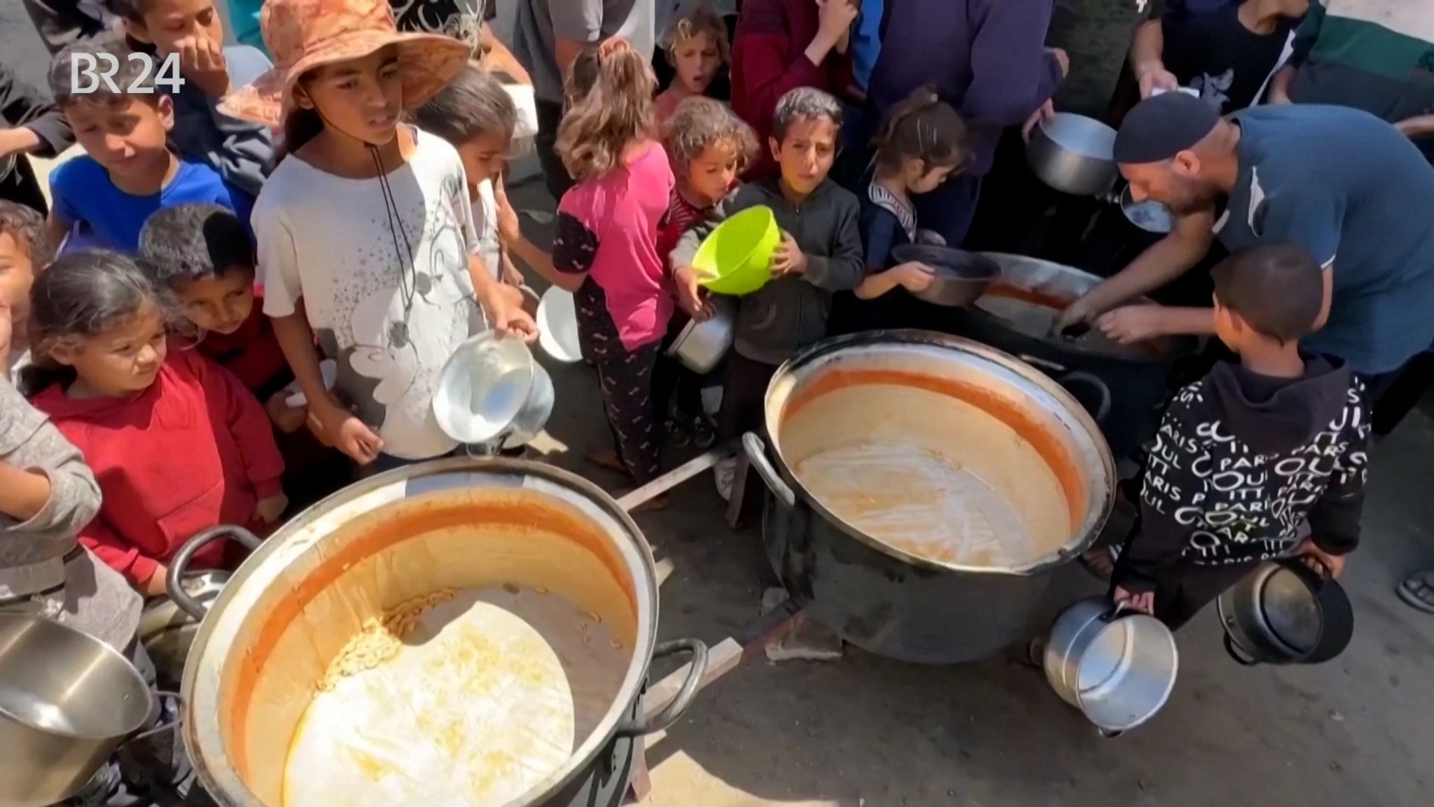Hungernde Kinder vor leeren Essenstöpfen