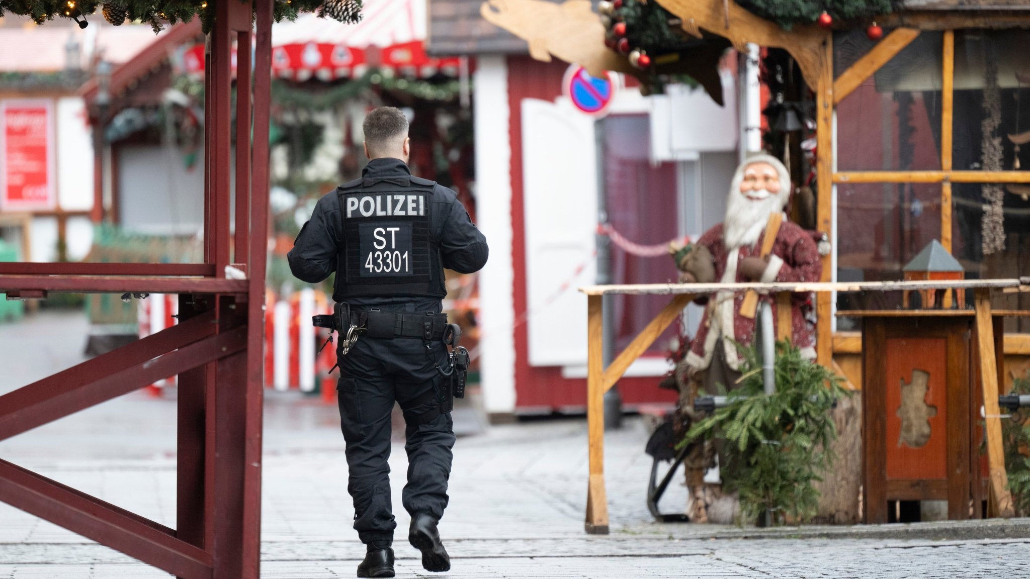 22.12.2024, Sachsen-Anhalt, Magdeburg: Ein Polizist geht über den gesperrten Weihnachtsmarkt. Am 20. Dezember 2024 ist auf dem Weihnachtsmarkt in Magdeburg ein Autofahrer in eine Menschengruppe gefahren. Es gab mehrere Tote und Verletzte.