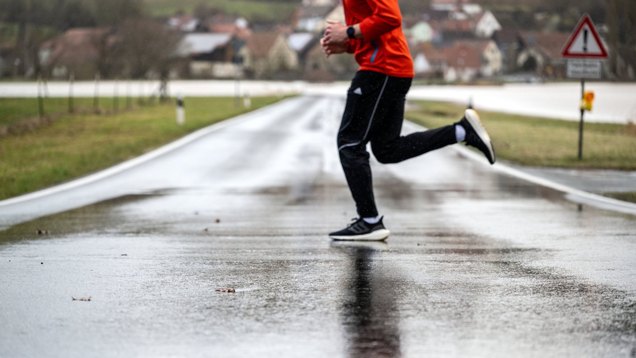 Ein Mann joggt bei Busendorf im Landkreis Bamberg am Hochwasser der Itz entlang. | Bild: dpa-Bildfunk/Pia Bayer Ein Mann joggt bei Busendorf im Landkreis Bamberg am Hochwasser der Itz entlang.