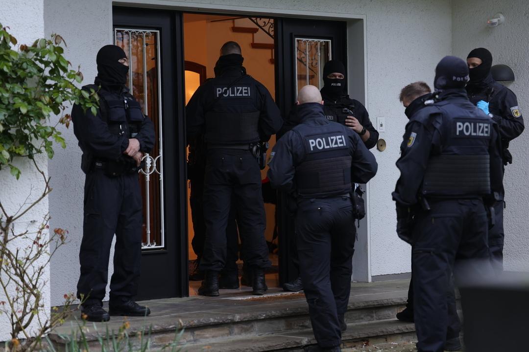 17.04.2024, Solingen: Polizeibeamte stehen an einem Gebäude, das durchsucht wird. Bei einer groß angelegten Razzia gegen eine international agierende Schleuserbande in acht Bundesländern hat die Staatsanwaltschaft Düsseldorf zehn Verdächtige verhaften lassen. 