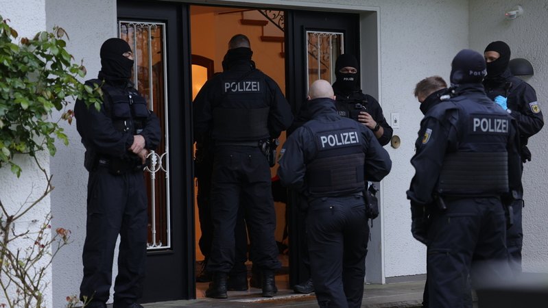 17.04.2024, Solingen: Polizeibeamte stehen an einem Gebäude, das durchsucht wird. Bei einer groß angelegten Razzia gegen eine international agierende Schleuserbande in acht Bundesländern hat die Staatsanwaltschaft Düsseldorf zehn Verdächtige verhaften lassen. 
