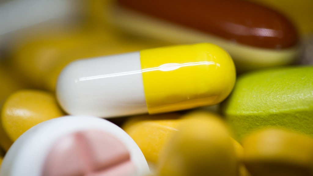 Vitaminkapseln in verschiedenen Farben und Formen, meist gelb-weiß.