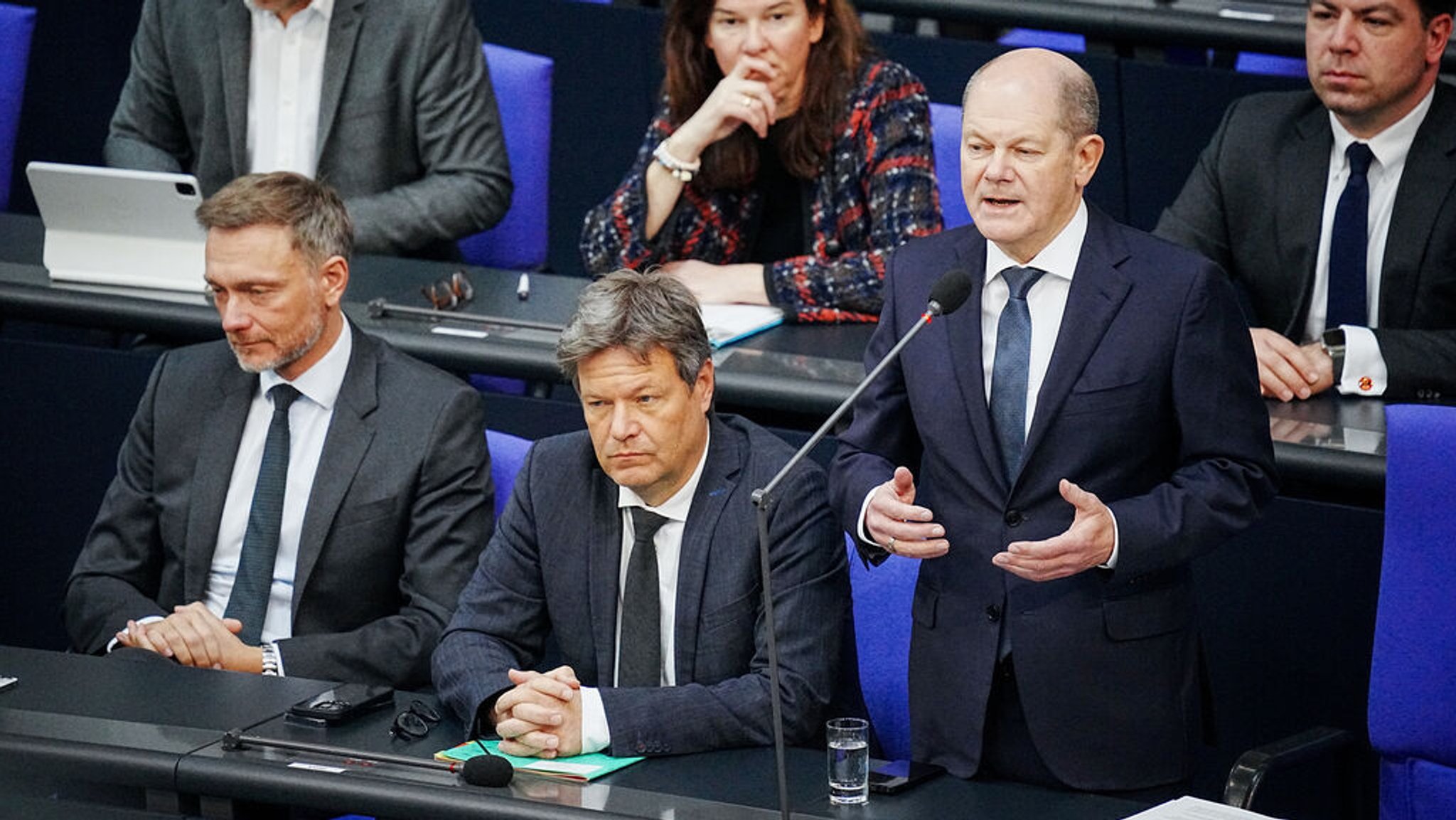 29.03.2023, Berlin: Bundeskanzler Olaf Scholz (SPD, 2.v.r) spricht im Bundestag bei der Befragung der Bundesregierung neben Christian Lindner (FDP, l), Bundesminister der Finanzen, und Robert Habeck (Bündnis 90/Die Grünen, M), Bundesminister für Wirtschaft und Klimaschutz, zu den Abgeordneten im Plenum. Foto: Kay Nietfeld/dpa +++ dpa-Bildfunk +++