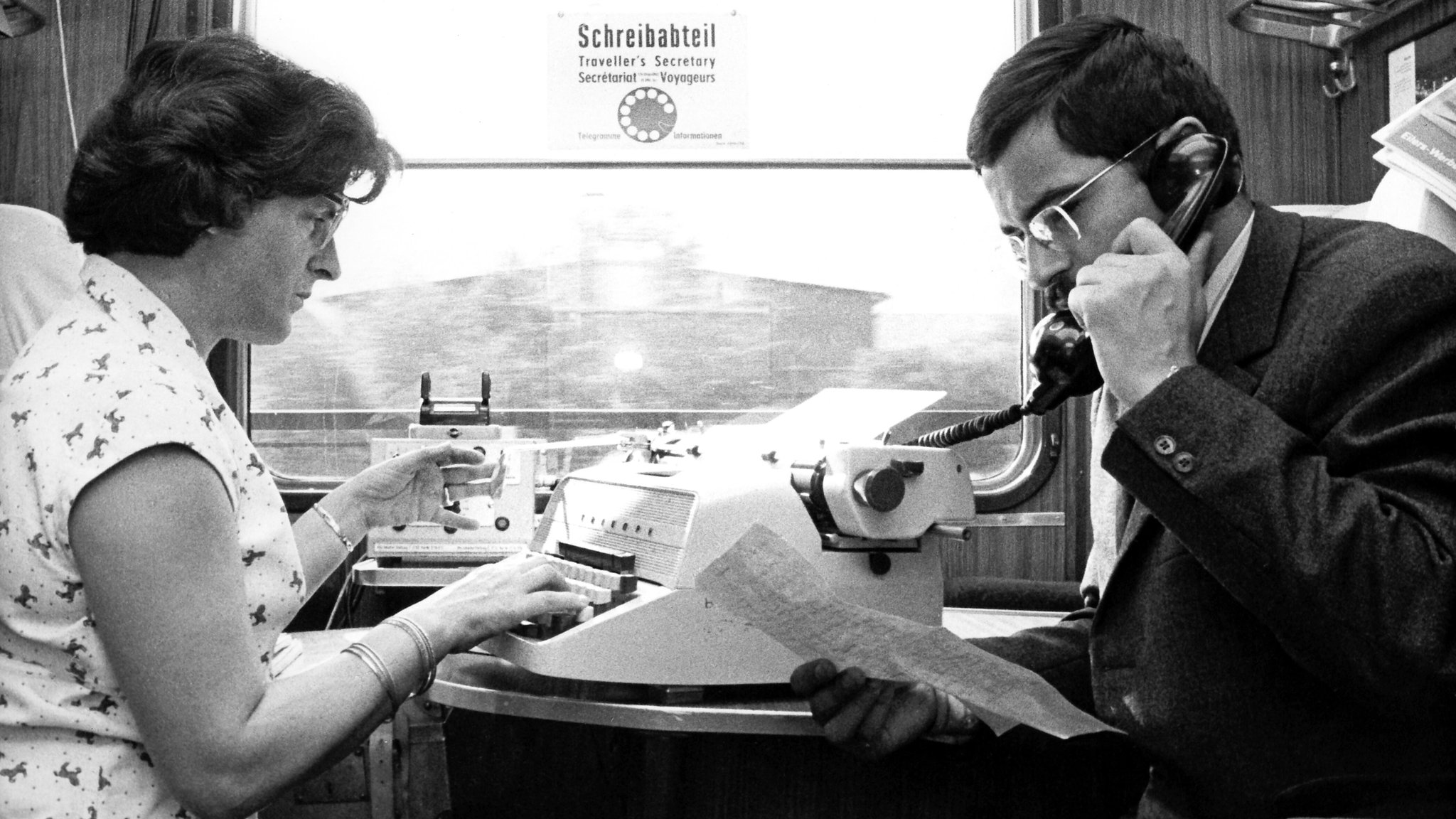 Während eine Sekretärin einen Brief auf einer Schreibmaschine tippt, telefoniert ihr Chef mit dem Telefon in einem Schreibabteil eines F-Zuges der Deutschen Bundesbahn. Aufnahme vom September 1968. | Bild: picture-alliance / dpa | Nöcker Während eine Sekretärin einen Brief auf einer Schreibmaschine tippt, telefoniert ihr Chef mit dem Telefon in einem Schreibabteil eines F-Zuges der Deutschen Bundesbahn. Aufnahme vom September 1968.
