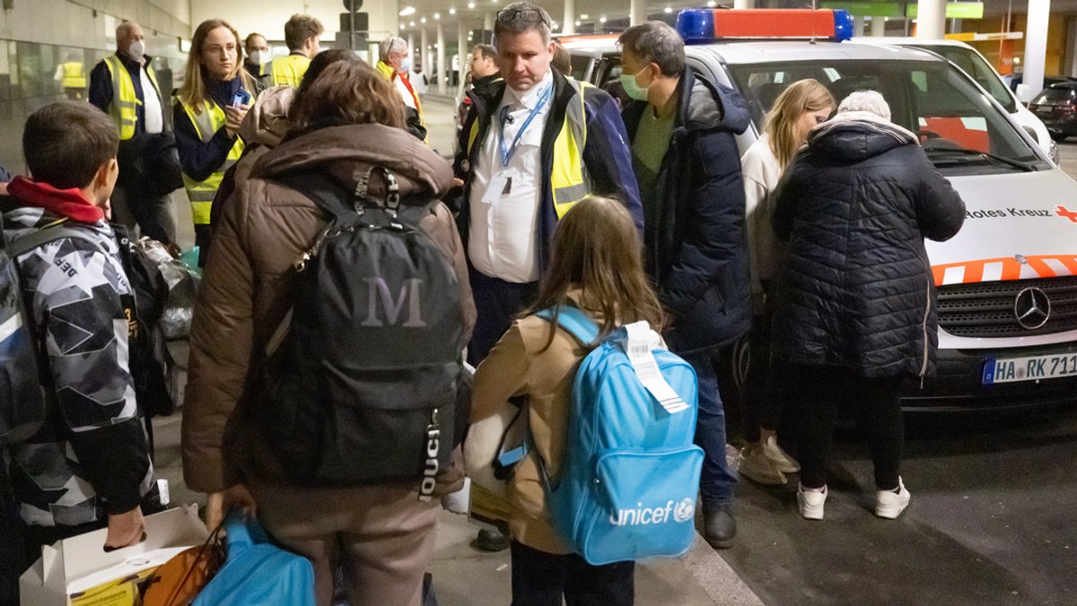 Evakuierte ukrainische Kriegsfüchtlinge warten nach einem Flug aus Moldavien am Flughafen auf den Weitertransport in Fahrzeugen des Deutschen Roten Kreuzes und des Arbeiter-Samariter-Bundes zu einer Erstaufnahmeeinrichtung. 